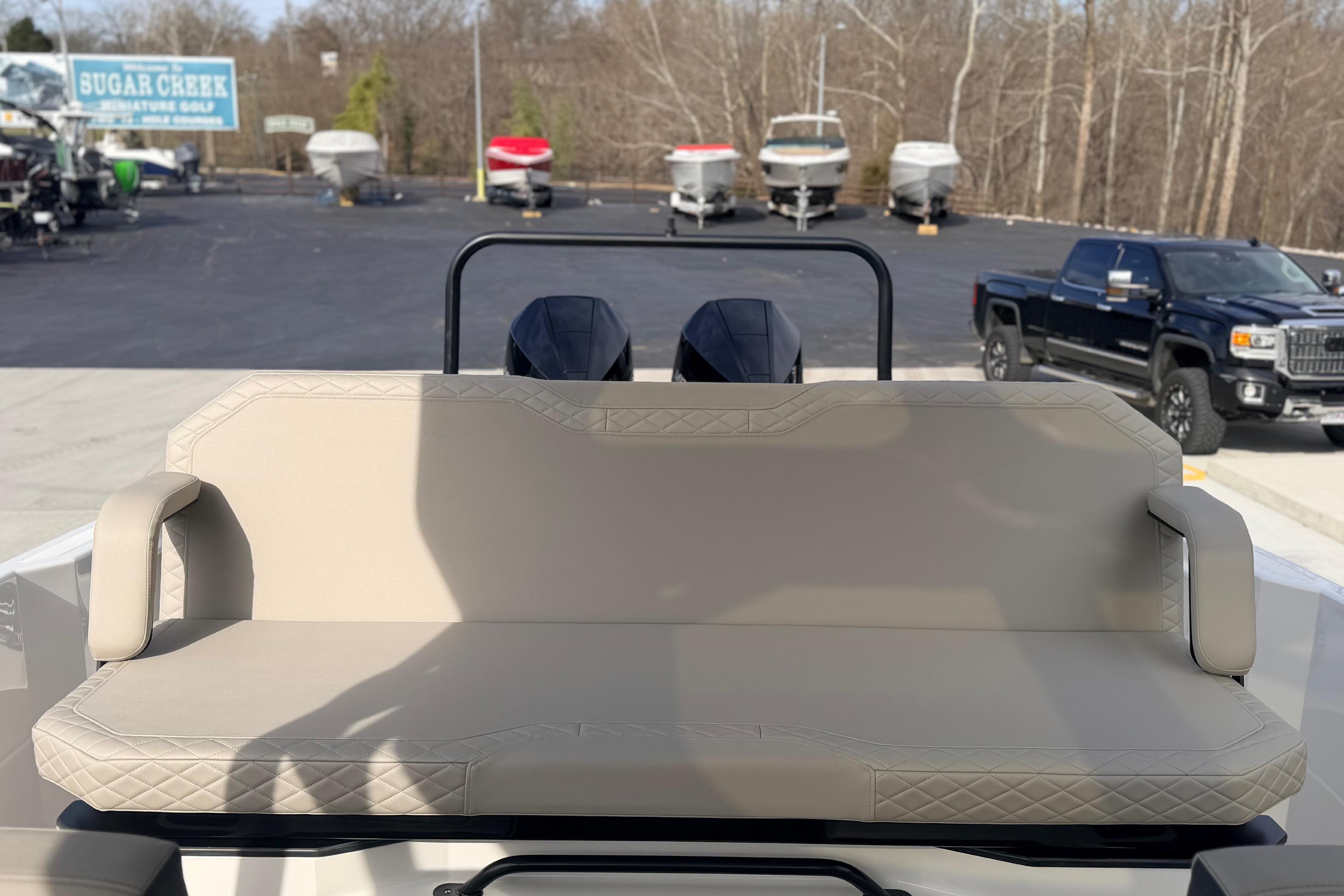 Rear view of 2026 Navan S30 boat with beige seating, parked near dealership.