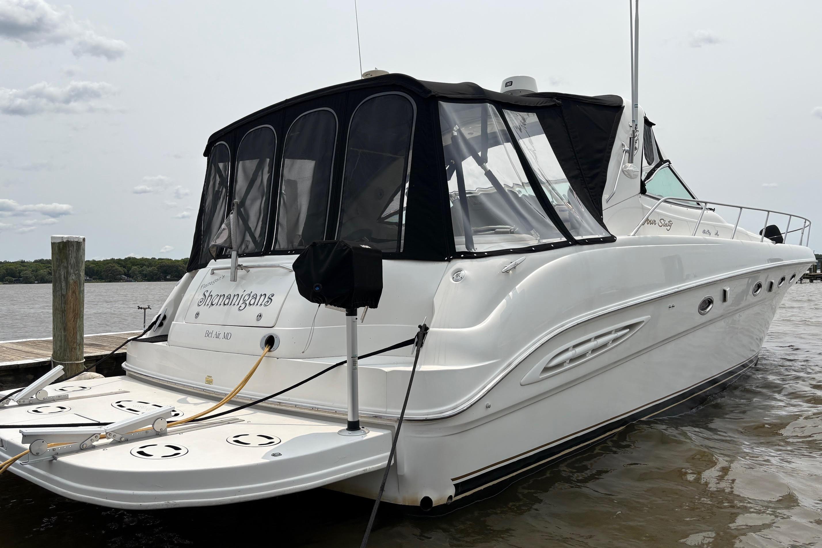 2001 Sea Ray 460 Sundancer yacht docked, featuring sleek design and black canopy.