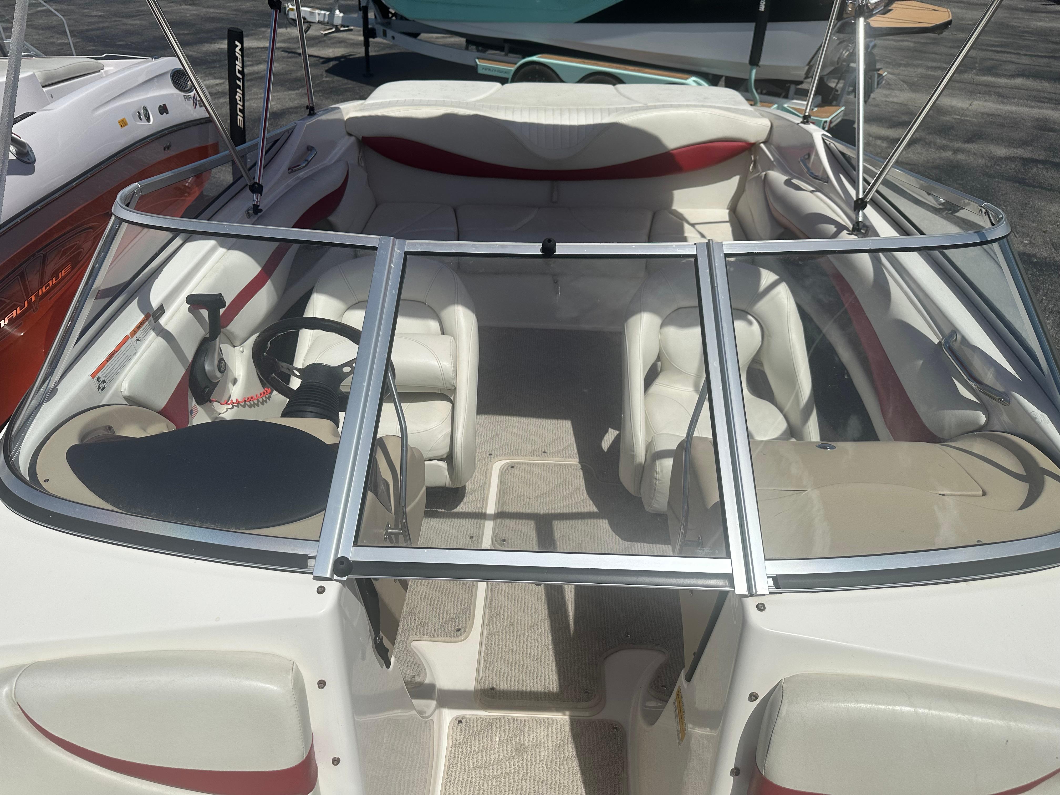 2008 Glastron 205 GX boat interior with white and red seating, steering wheel, and windshield.