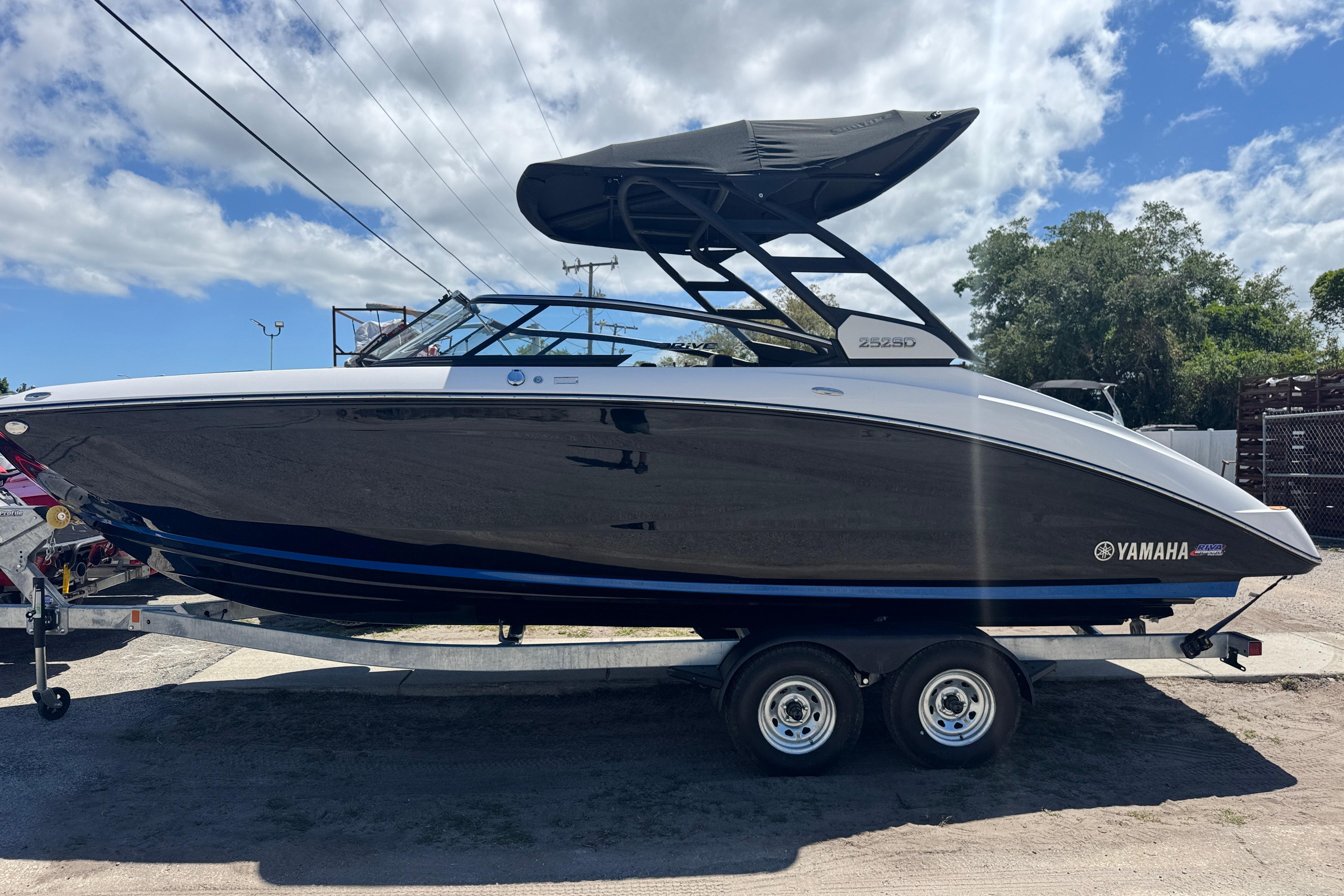 2026 Yamaha Boats 252SD on trailer, sleek design under a partly cloudy sky.