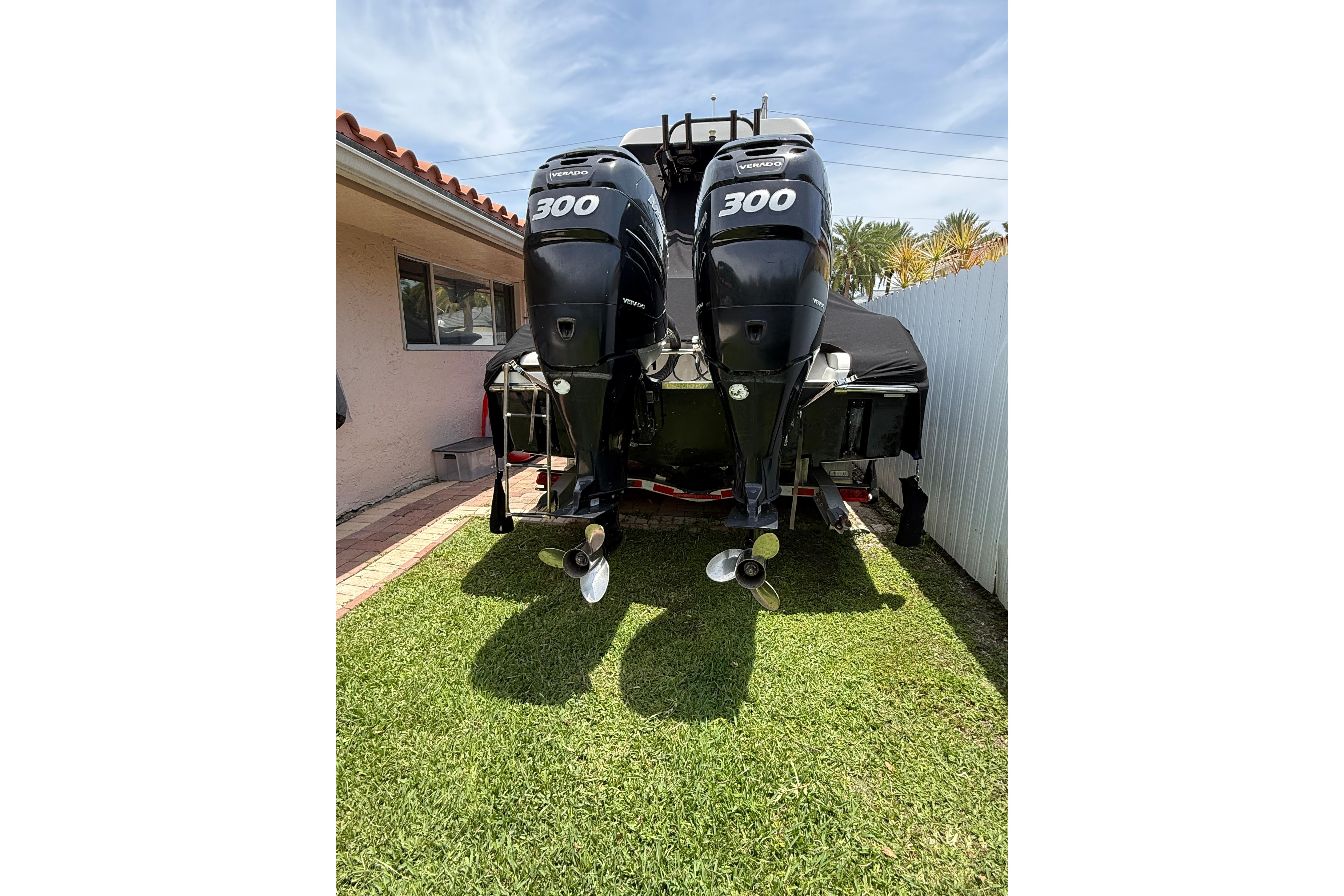 2015 Blackwood 27 boat with twin 300 horsepower engines, parked on grass.