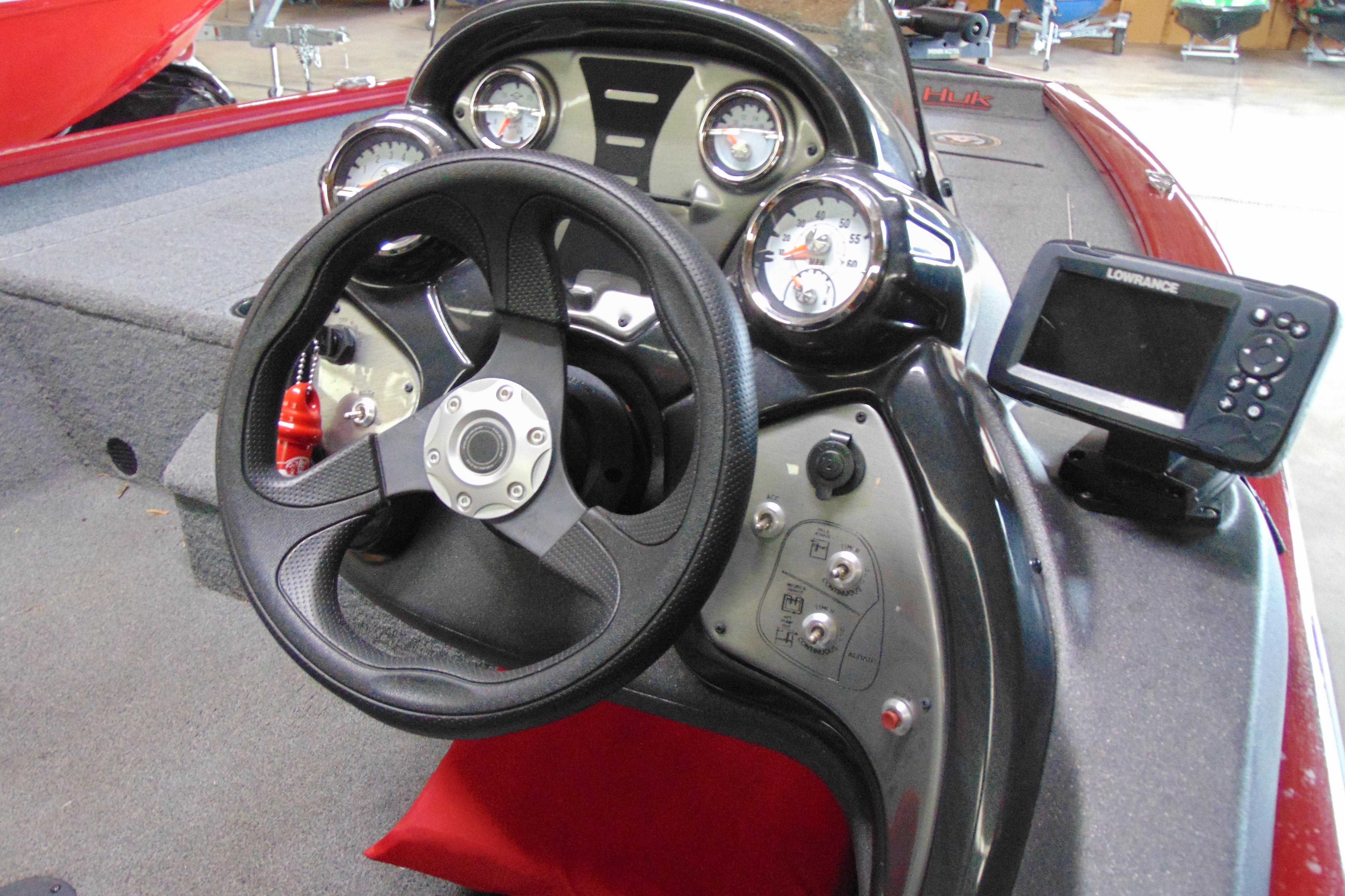 Bass Tracker Pro 17 boat dashboard with steering wheel and Lowrance fish finder, 2022 model.