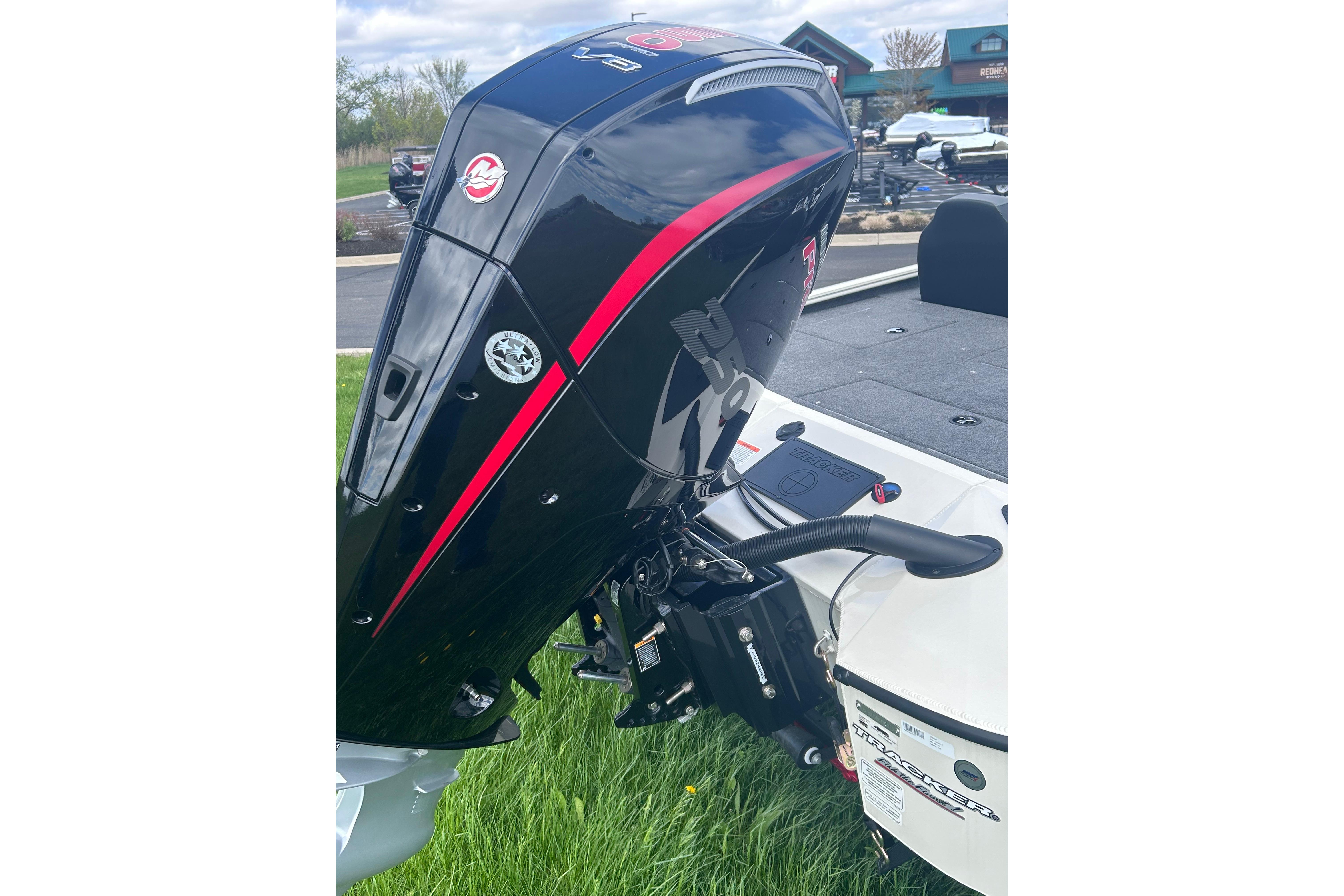 2025 Tracker Savage 215 boat engine, sleek black design with red accents, parked outdoors.