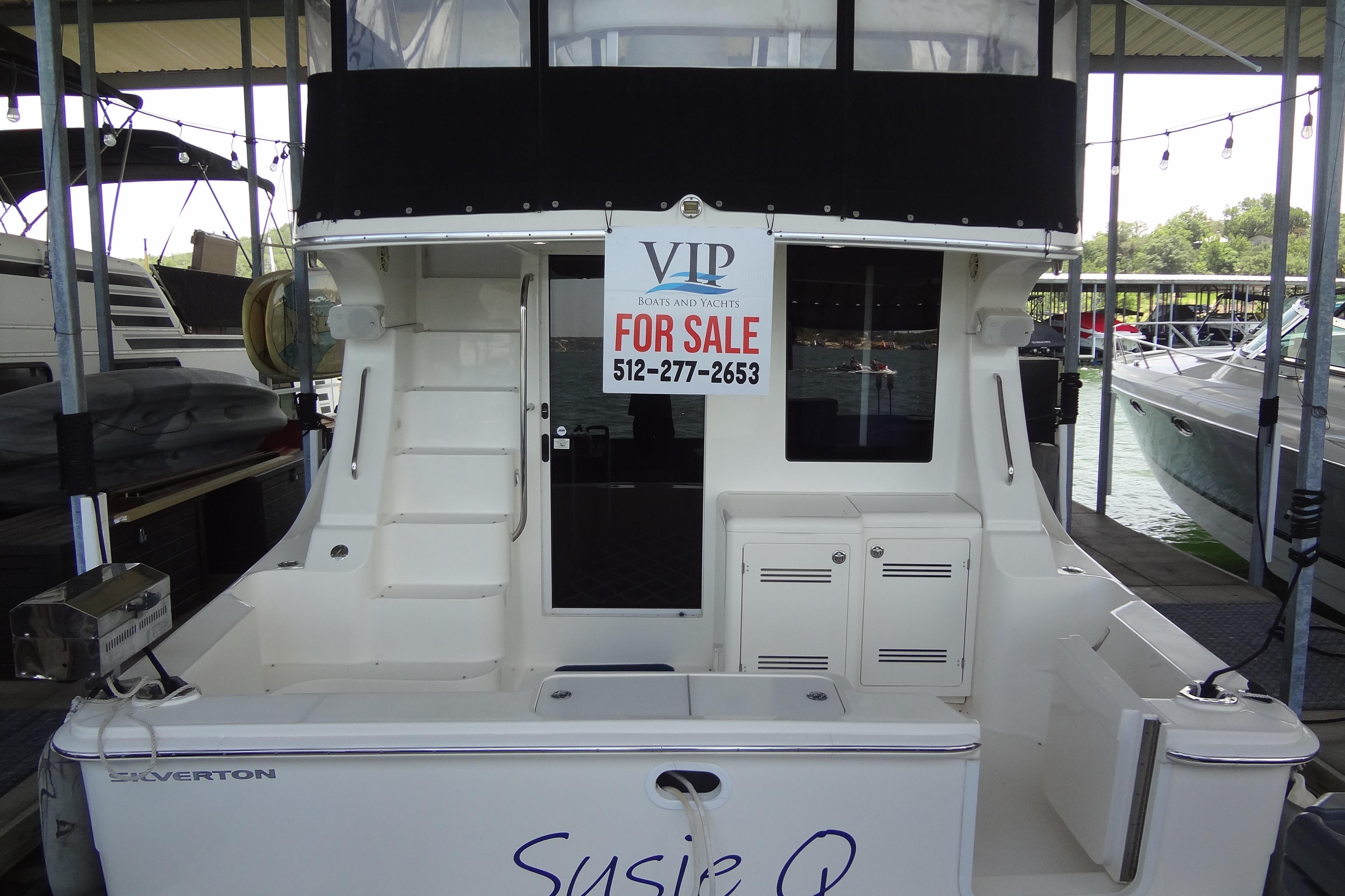 2005 Silverton 34 Convertible boat for sale at marina dock.
