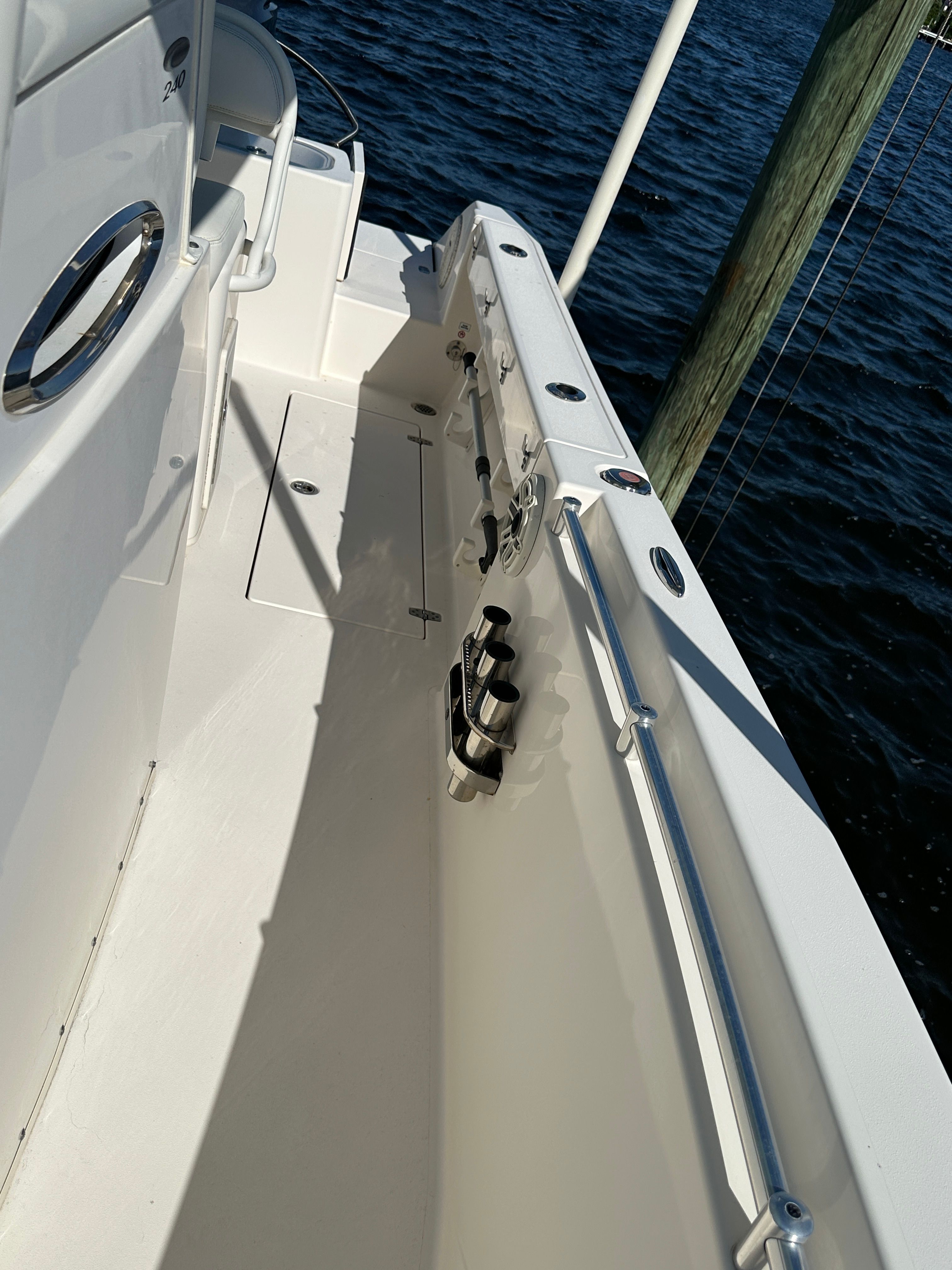 2022 Cobia 240 Center Console by the water with rod holders and a clean deck.