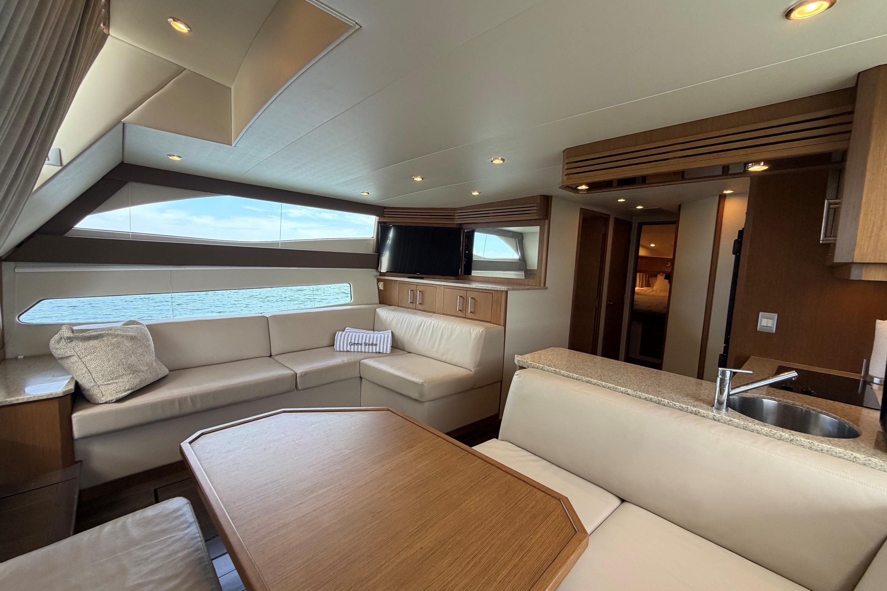 Luxurious interior of 2011 Carver 44 Sojourn yacht with modern seating and ocean view.