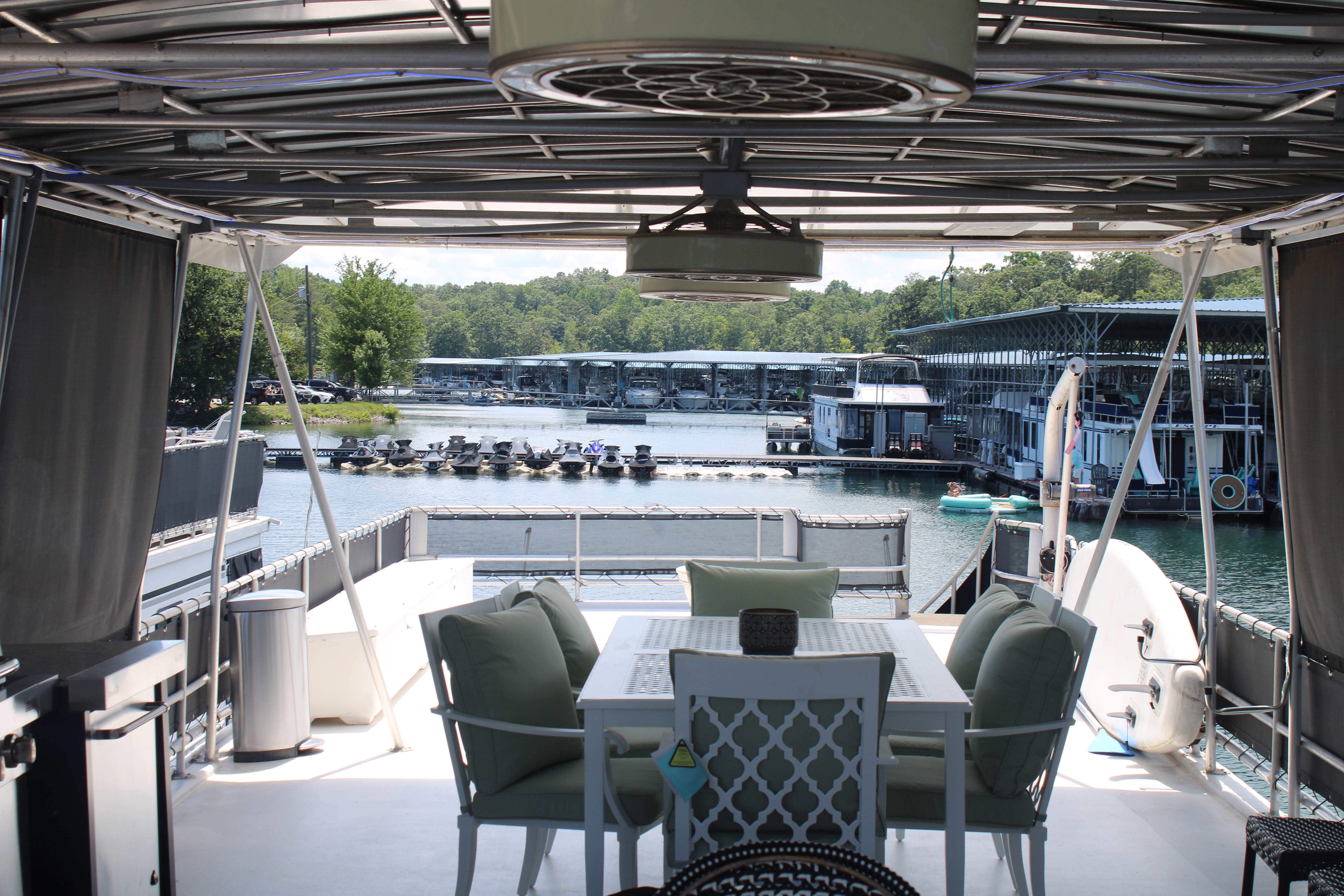 1992 Sumerset 66 houseboat interior with outdoor seating, overlooking marina and water.