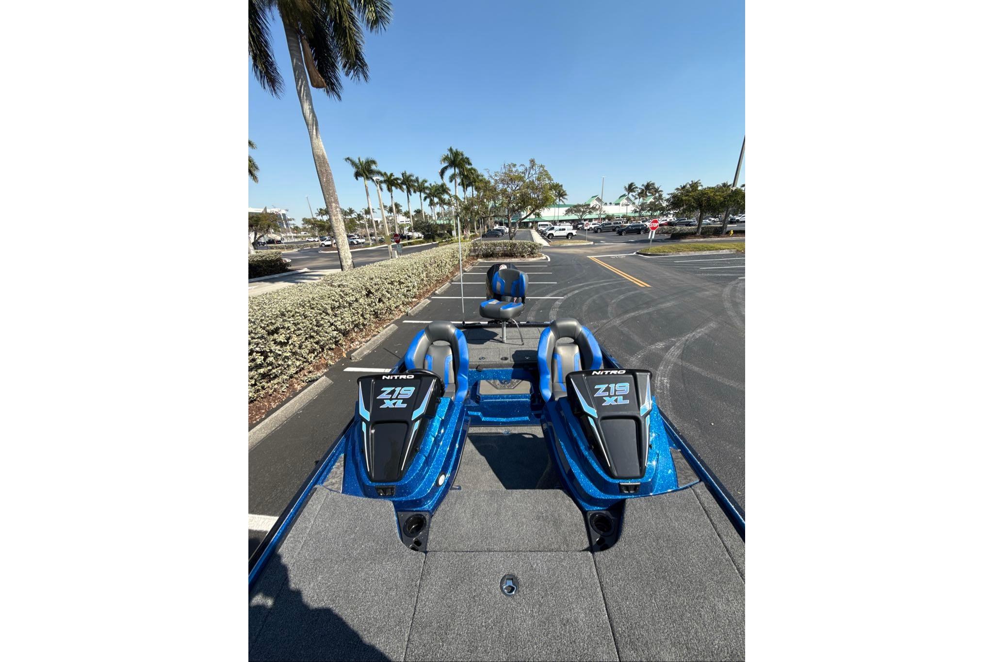 2026 Nitro Z19 XL boat in parking lot, surrounded by palm trees.