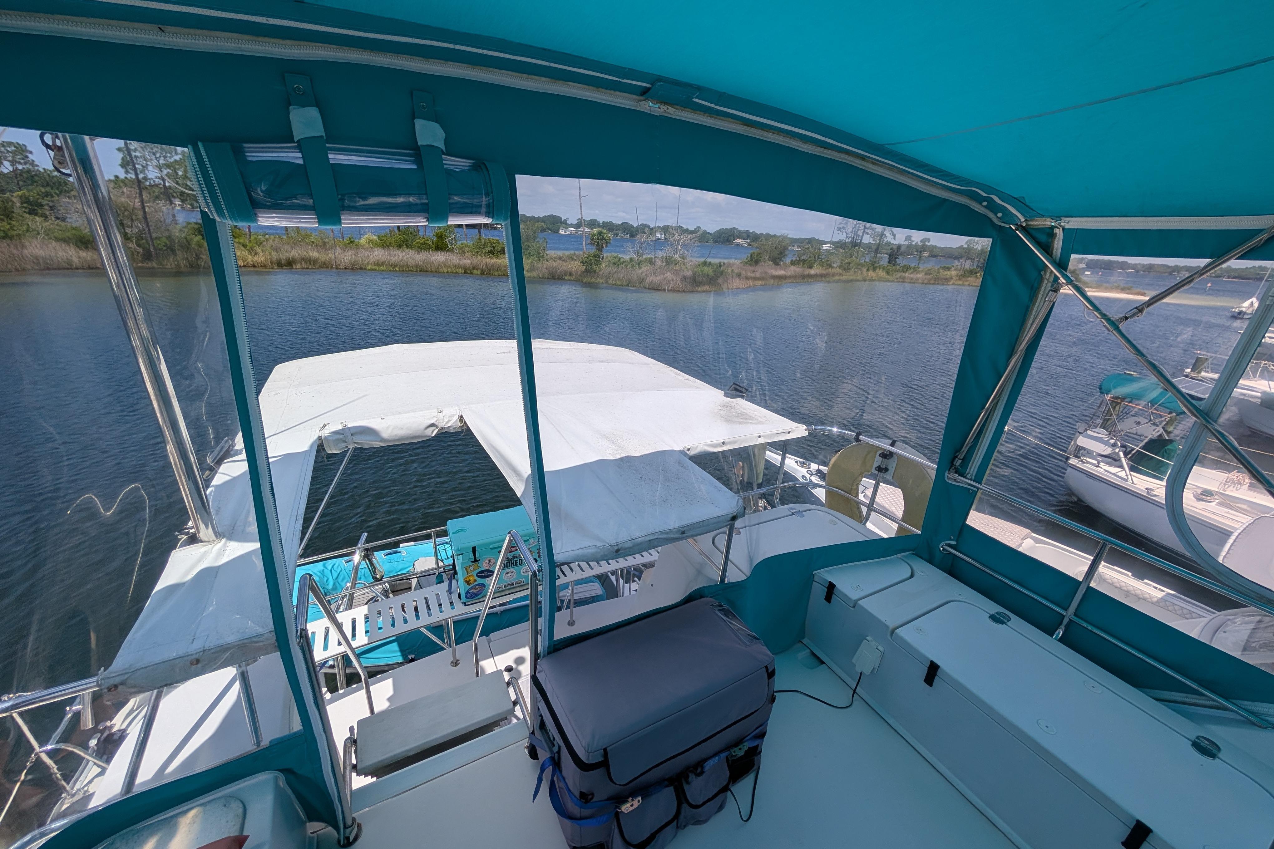 2004 PDQ 34 Powercat interior view with blue canopy on calm water.
