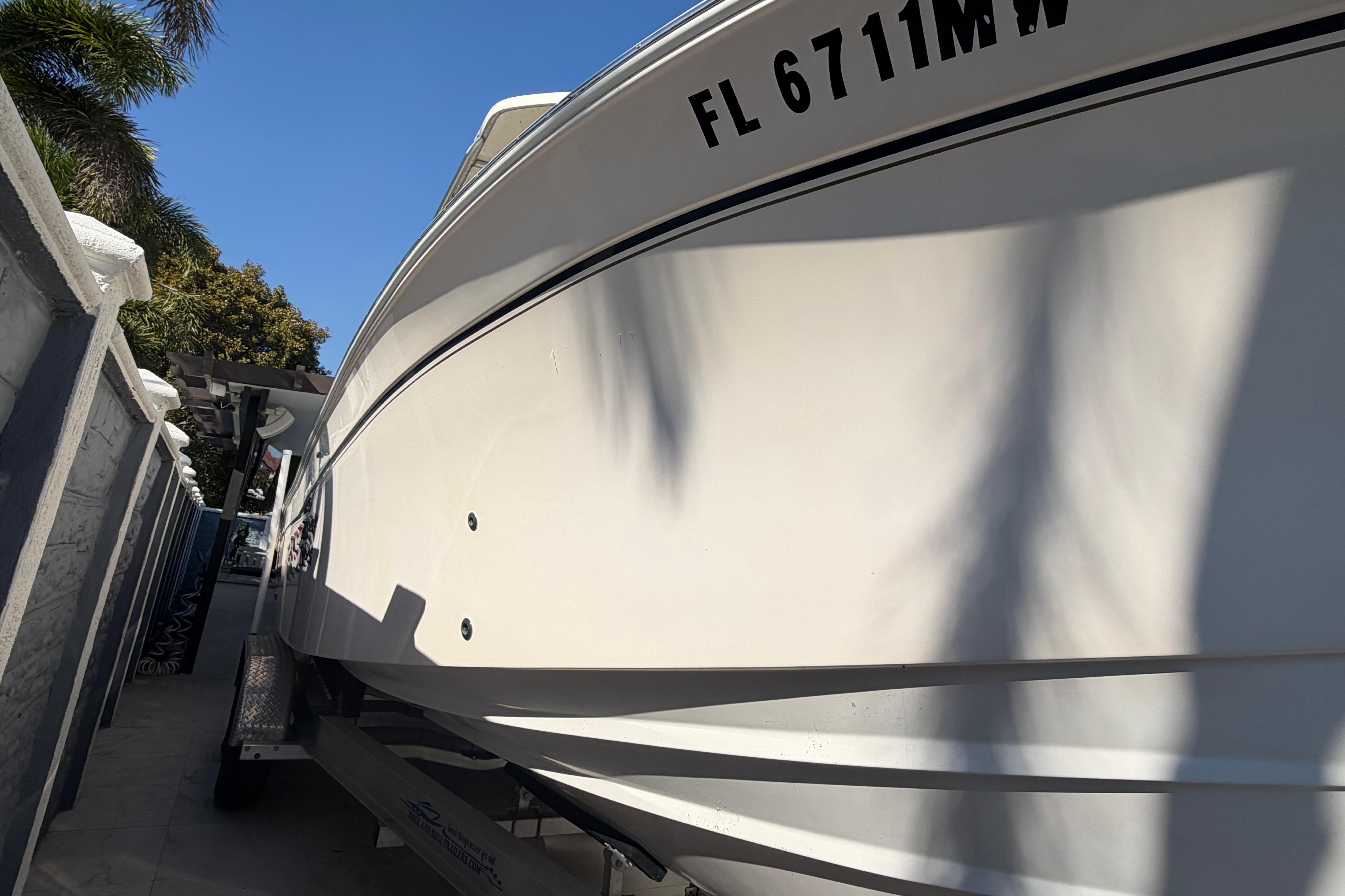 2004 Grady White 273 boat on trailer, side view with registration number visible.