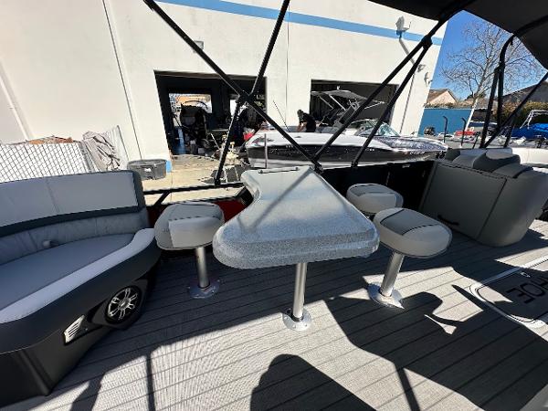 2025 Tahoe Pontoon 2585 LTZ Entertainer with seating and table on deck.