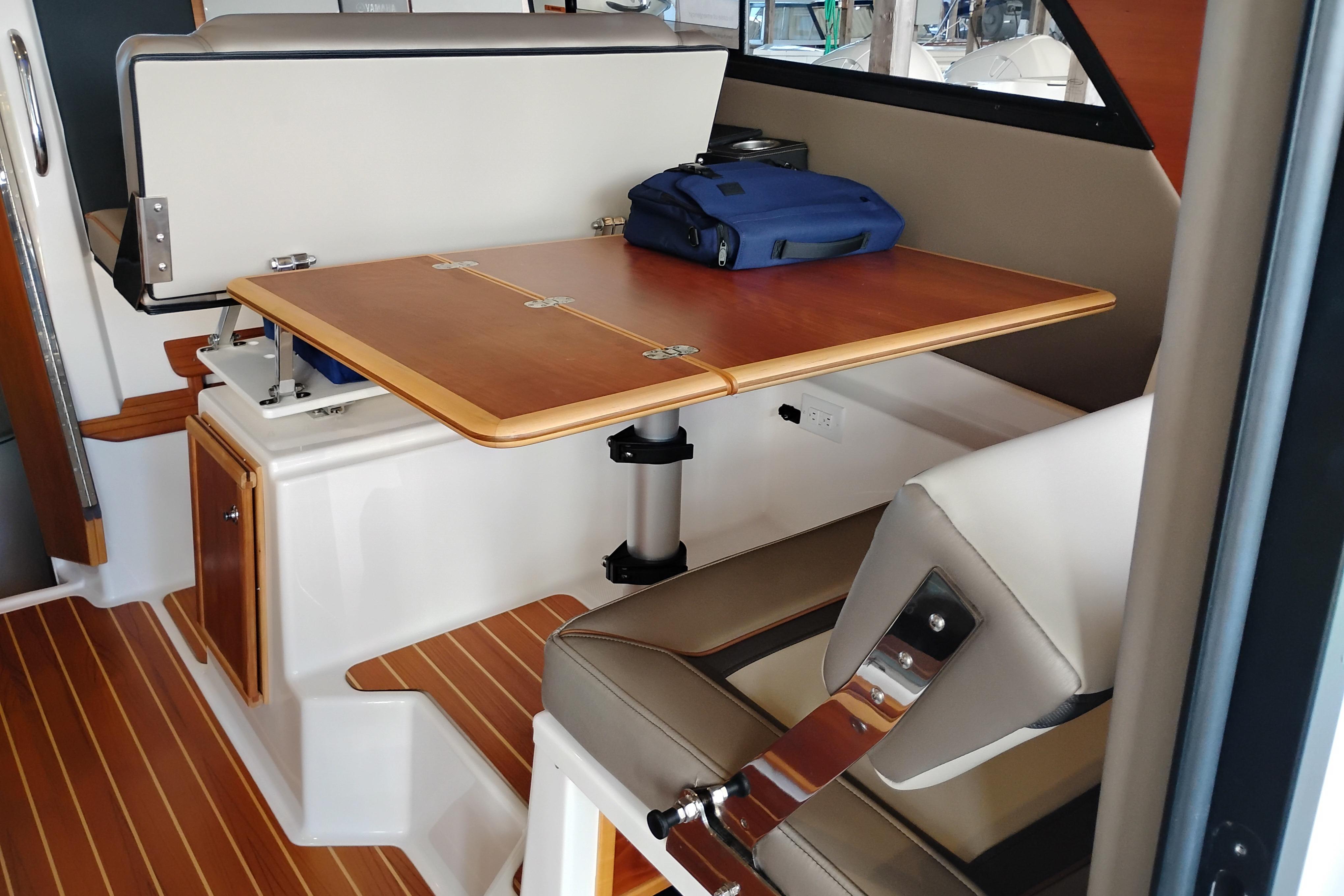 Interior of 2022 Cutwater C-32 Coupe with wooden table and seating area.
