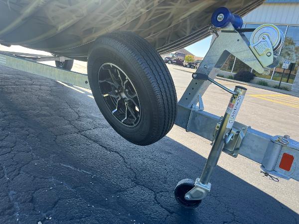 2025 Lowe Roughneck 2070 SC trailer wheel on asphalt, showcasing sturdy design and durability.