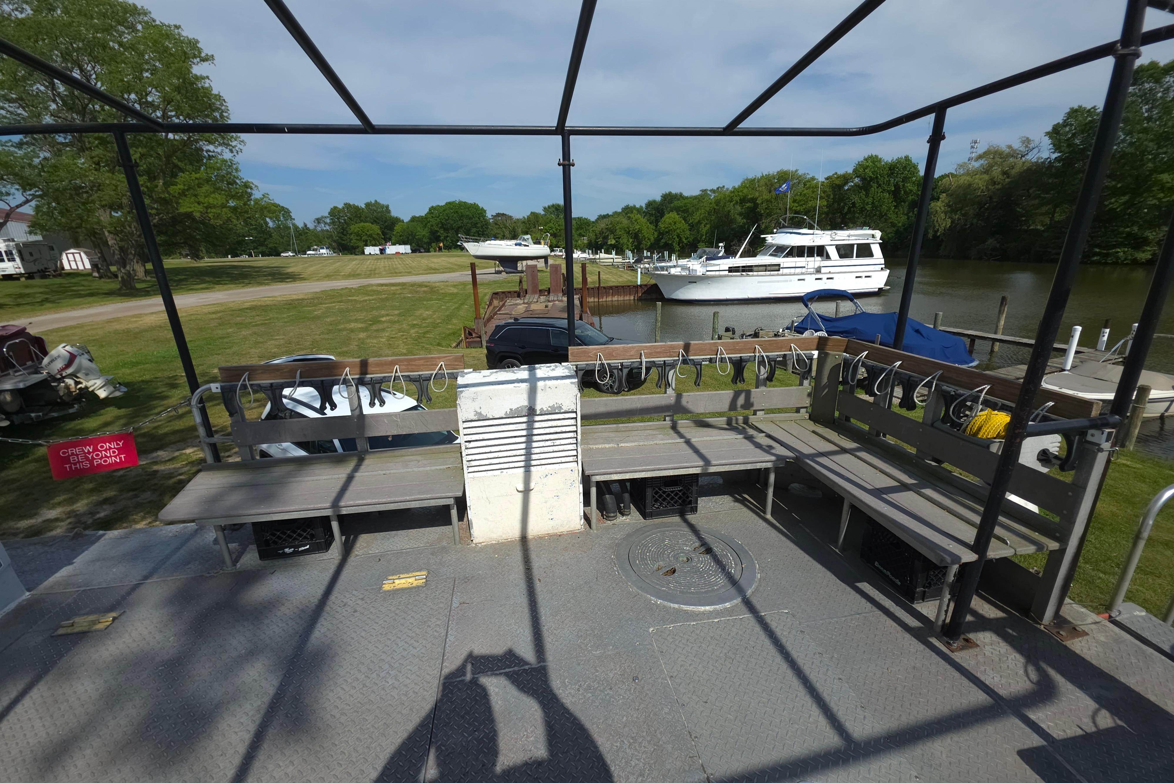 1974 Breaux's Bay Craft passenger boat docked near a river with benches and safety equipment.
