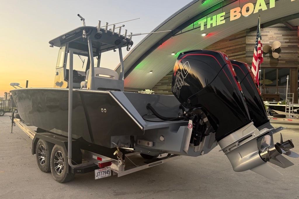 2019 Metal Shark 28 CC boat on trailer, dual engines, parked near a building at sunset.