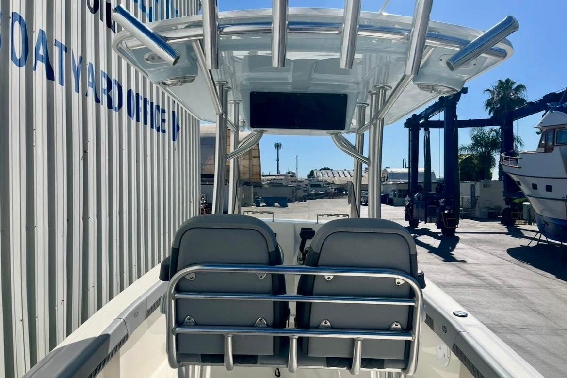 2025 Defiance Catalina 240 boat interior at a marina, featuring dual seats and a T-top.
