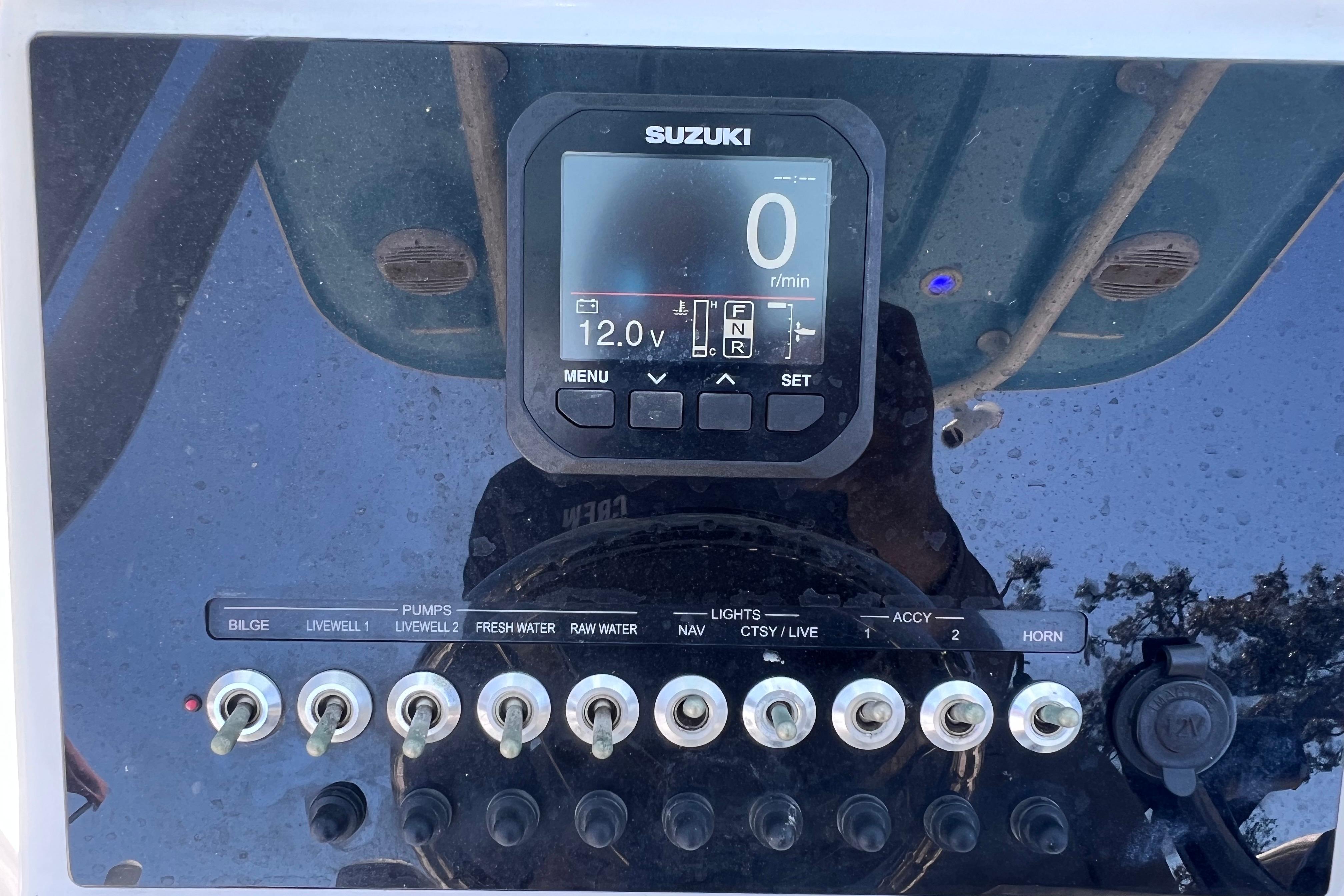 Control panel of 2023 Sea Pro 248 Bay boat with Suzuki display and switches.