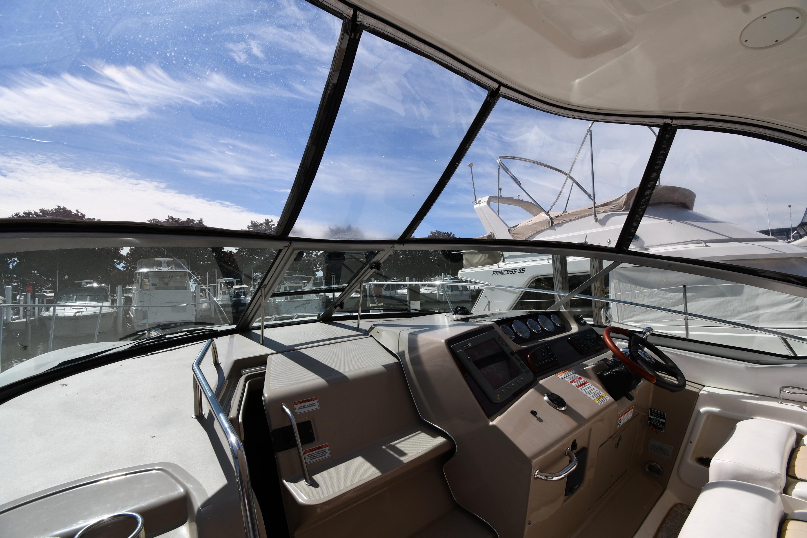 Interior view of 2008 Sea Ray Sundancer 350 yacht cockpit with steering wheel and dashboard.