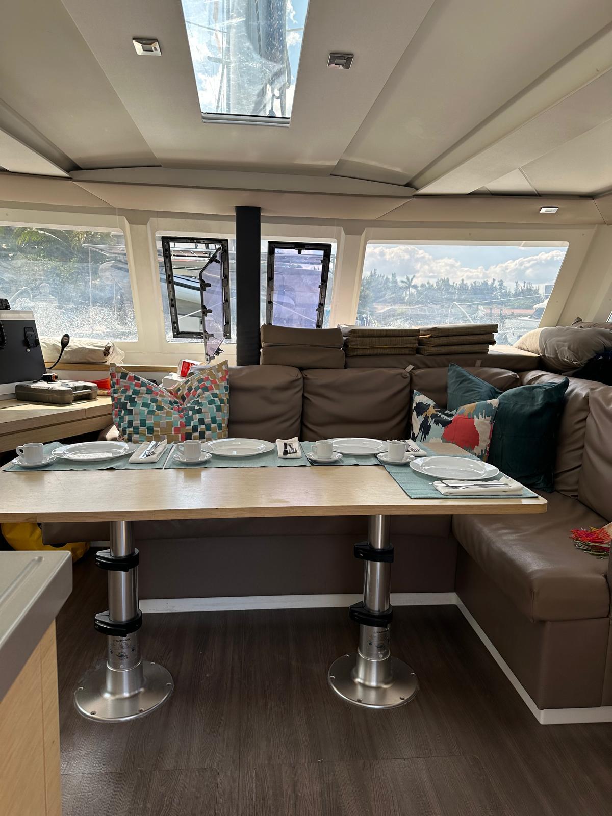 Interior of 2019 Fountaine Pajot Lucia 40 catamaran with dining area and plush seating.