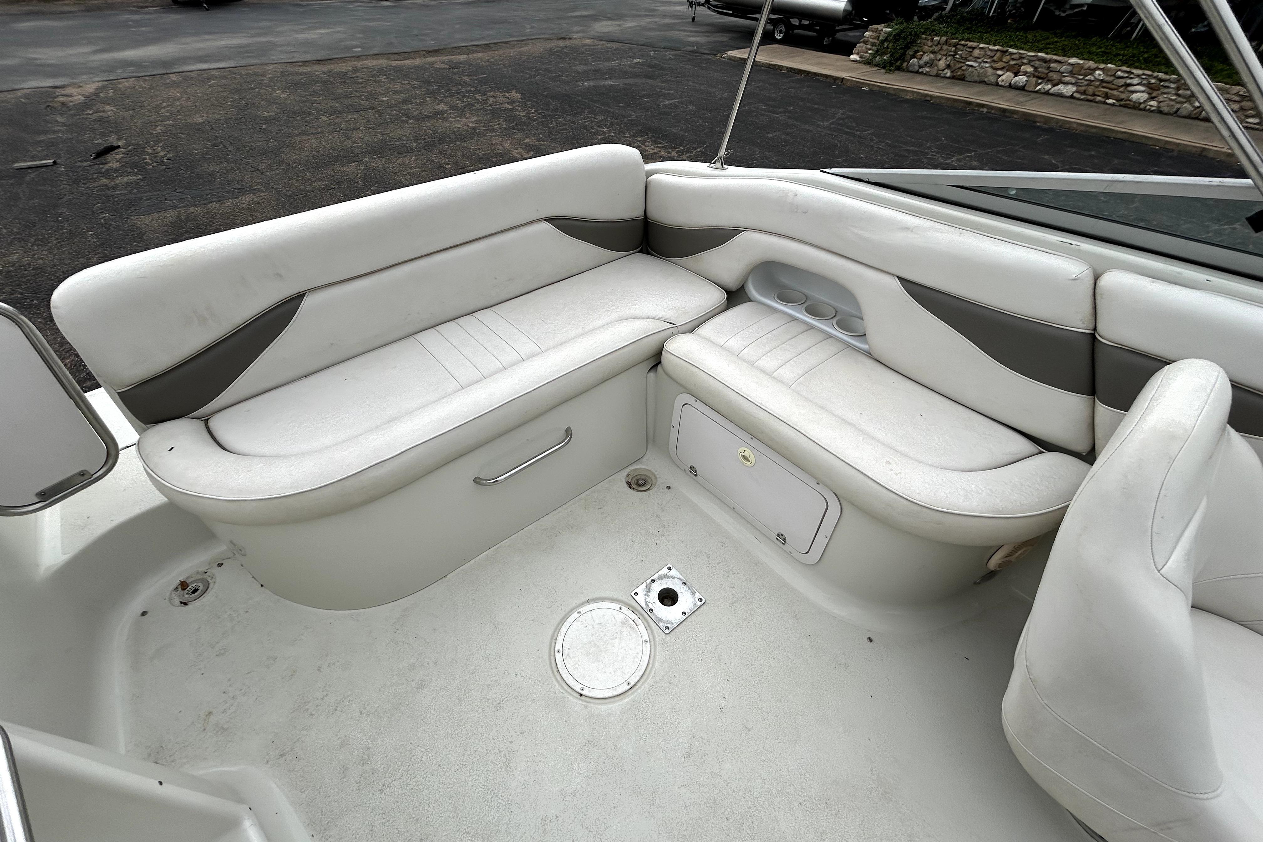 2001 Crownline 239 DB boat interior with white seating and storage compartments.