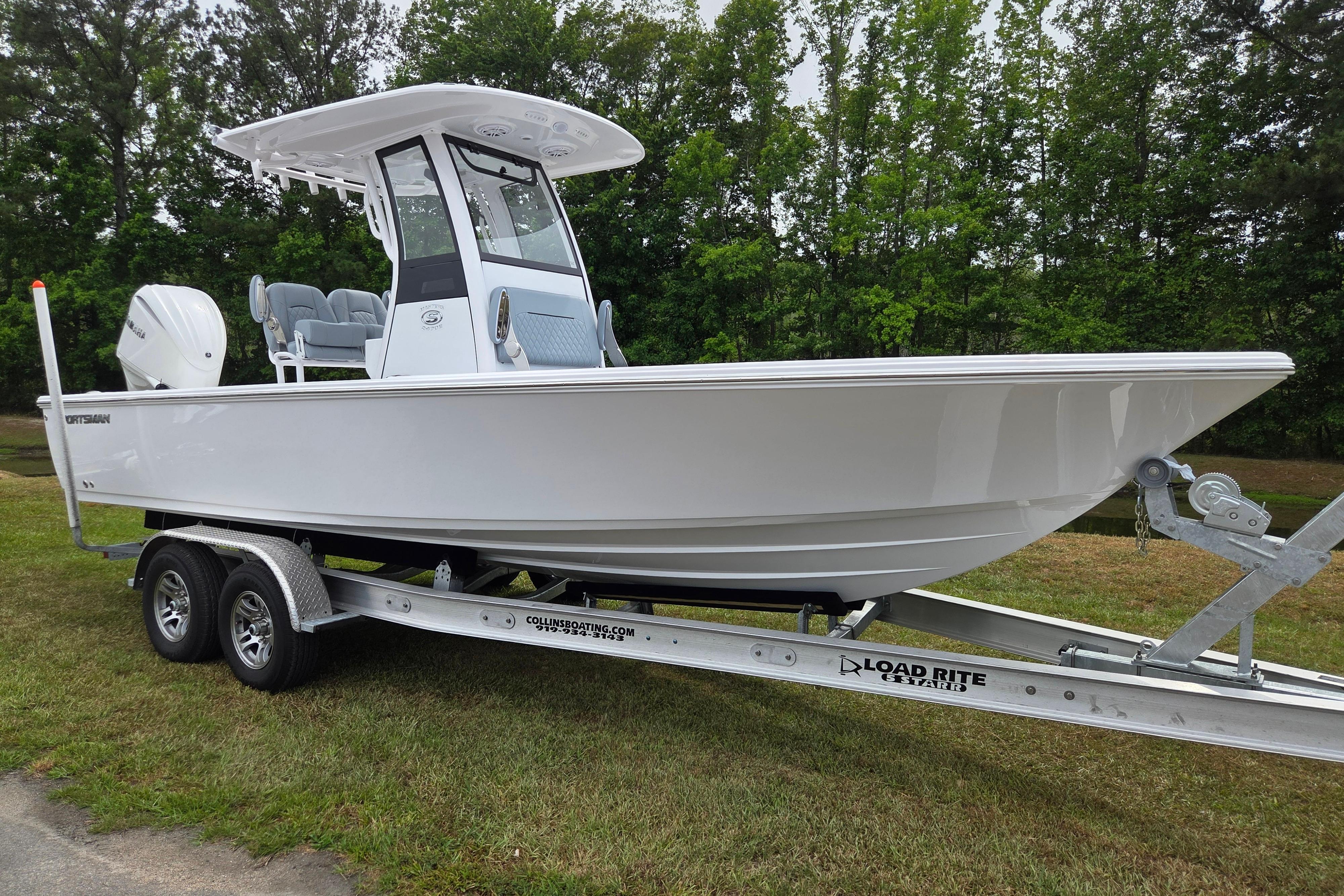 2026 Sportsman Masters 247OE Bay Boat on trailer, parked on grass.
