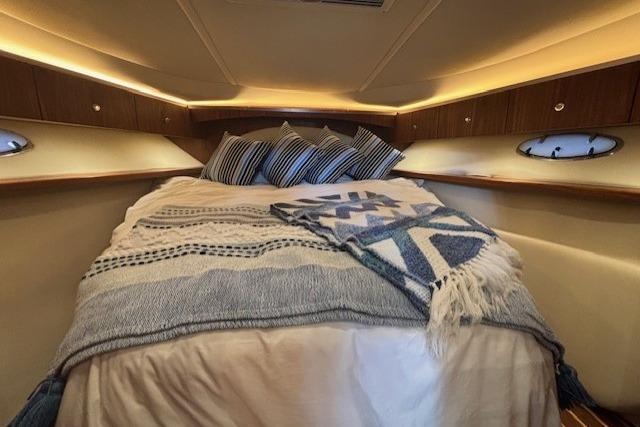 Cozy cabin interior of 2009 Tiara Yachts 3600 Open with plush bedding and ambient lighting.