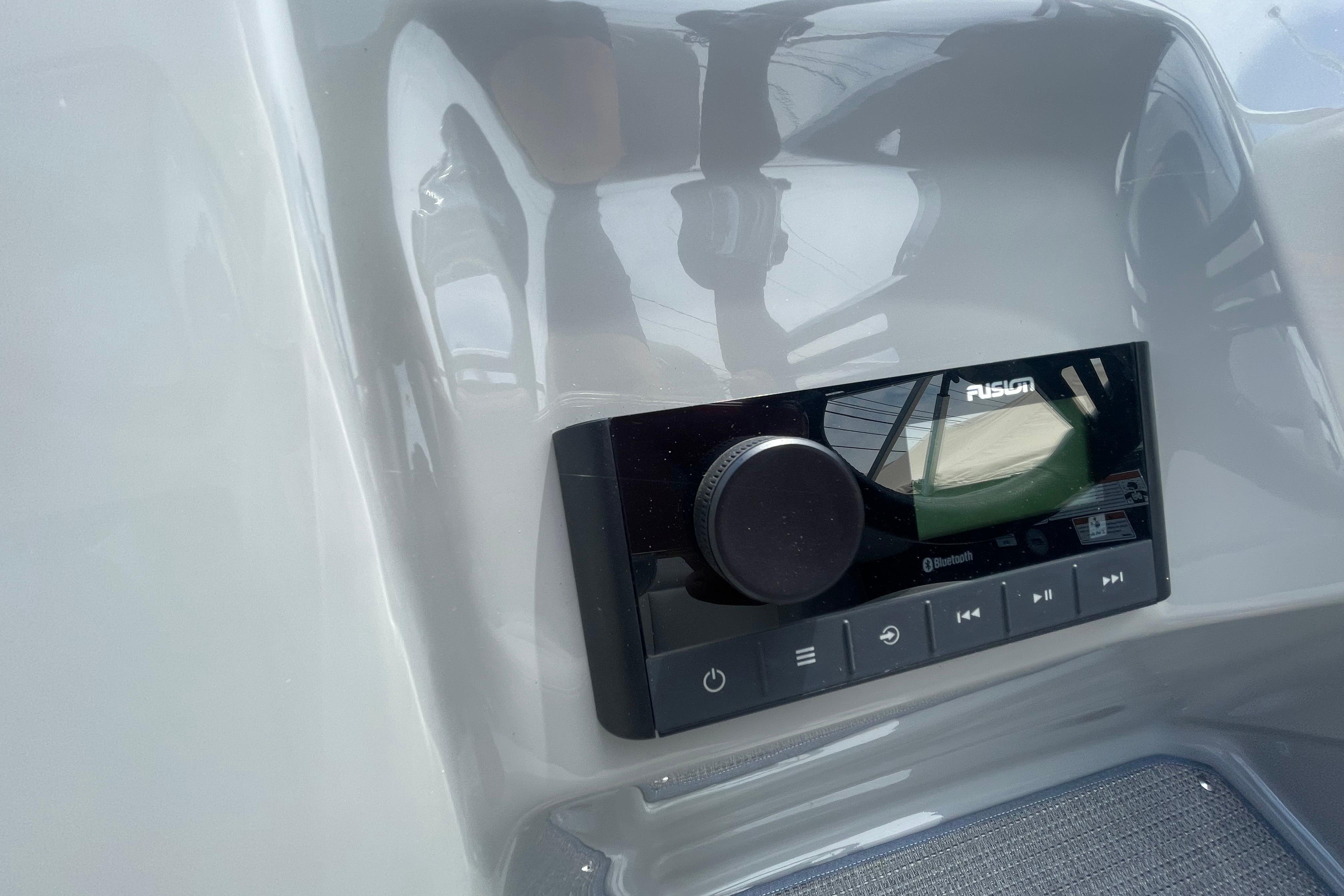 Control panel of 2022 Manitou 23 Oasis boat featuring a Fusion audio system.
