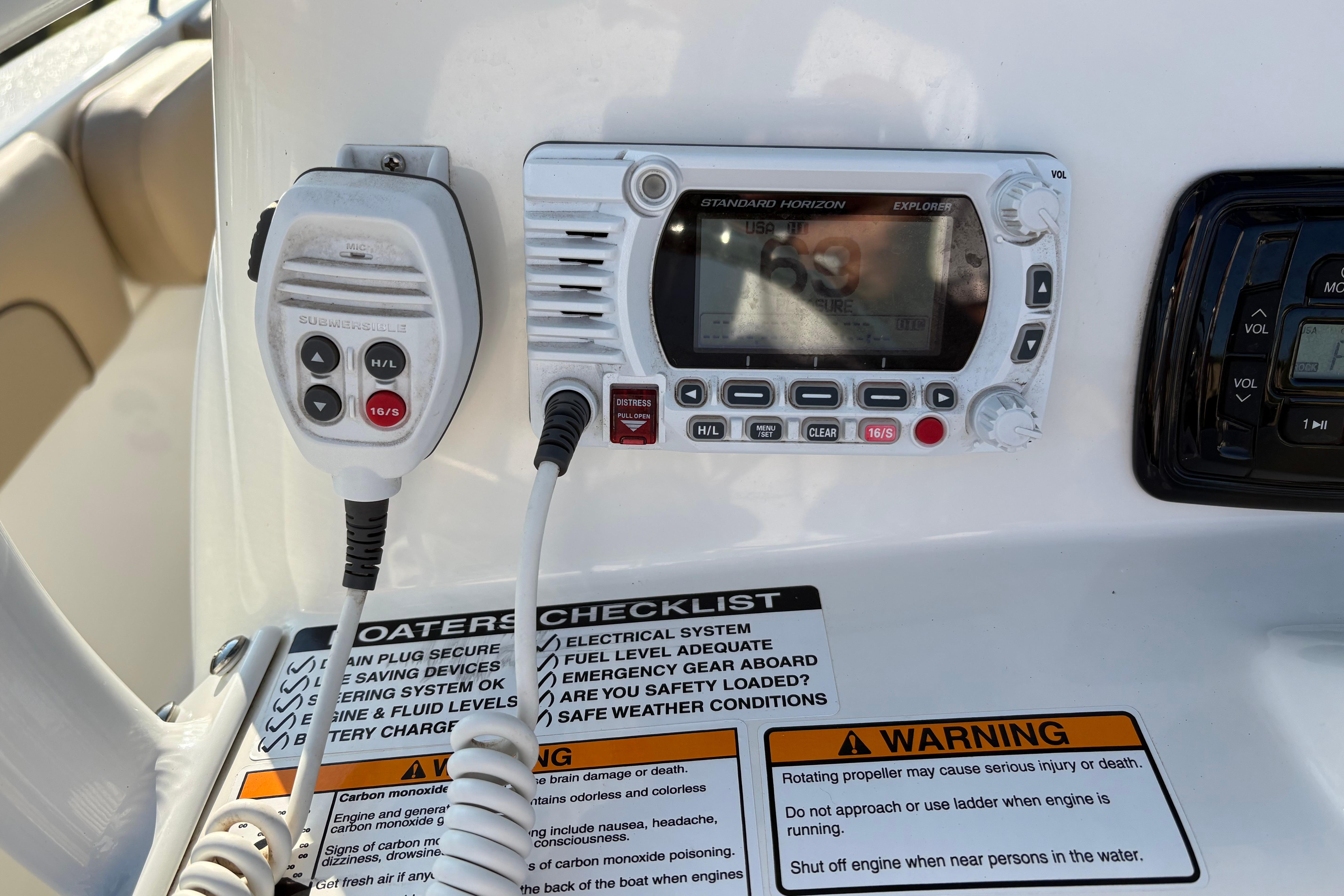 Control panel of a 2019 NauticStar 231 Hybrid boat with radio and safety checklist.
