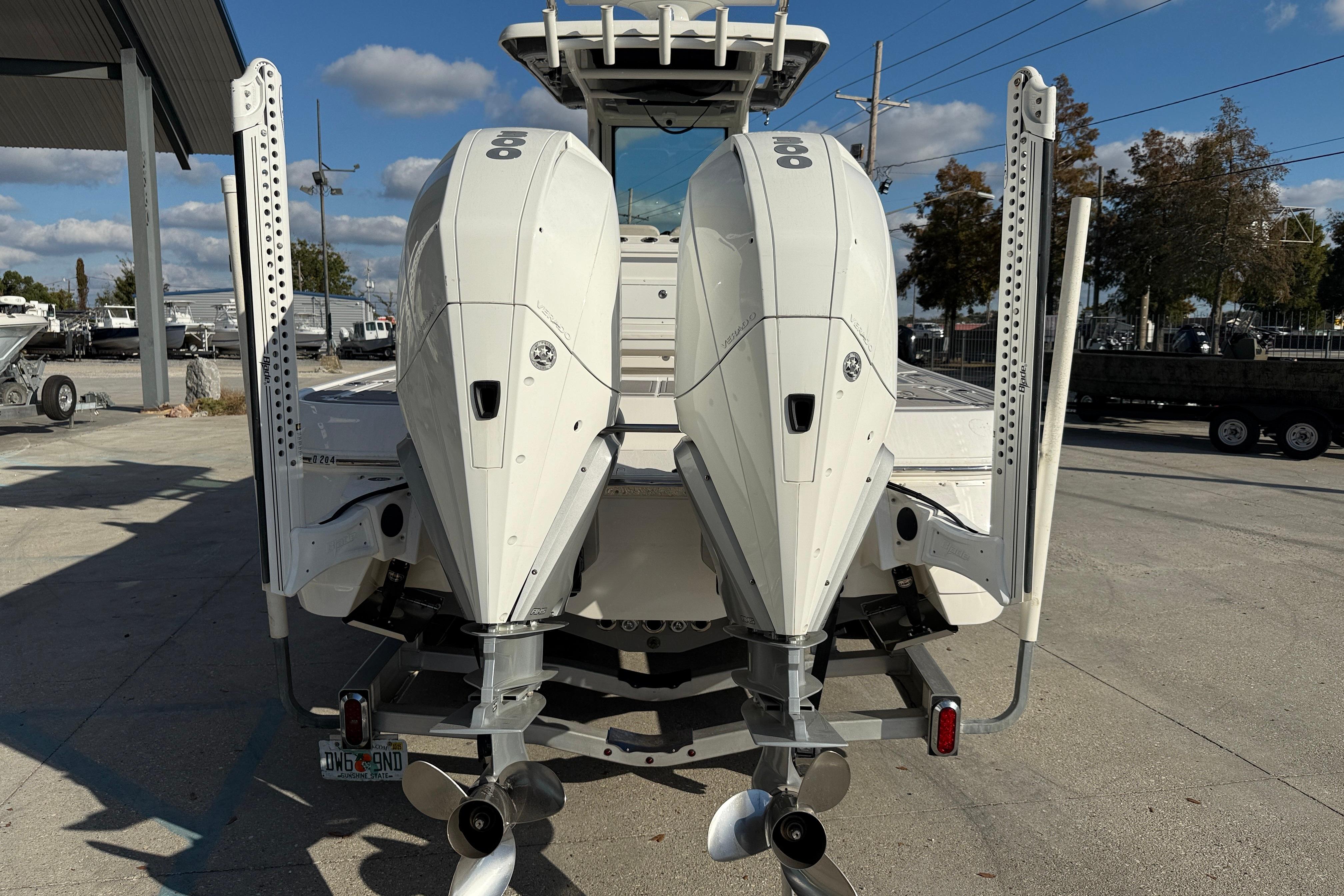 2022 Caymas 28 HB Twin boat with dual outboard engines, parked outdoors.