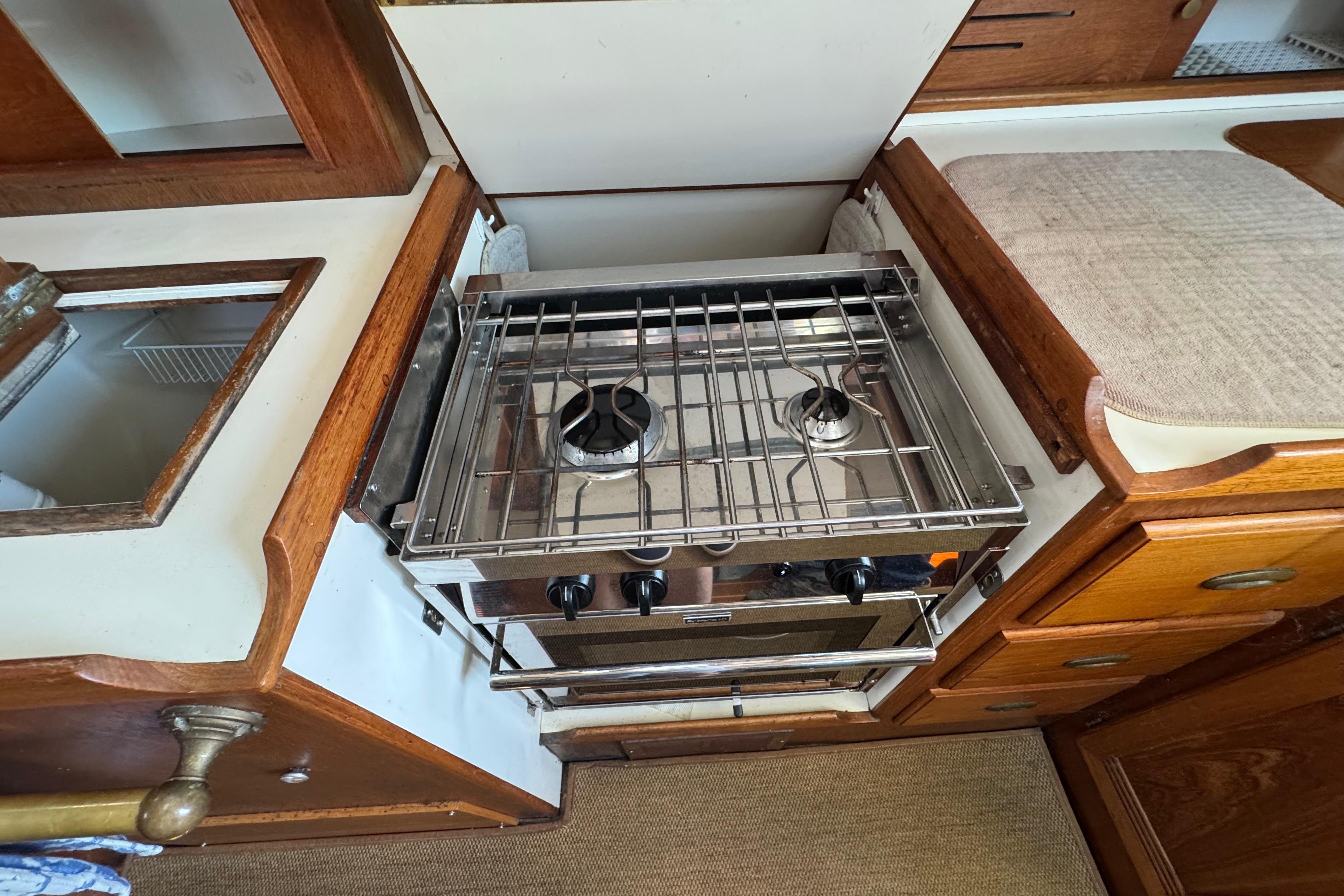 Compact kitchen area in a 1989 Cape Dory 30 Motorsailer with a two-burner stove.