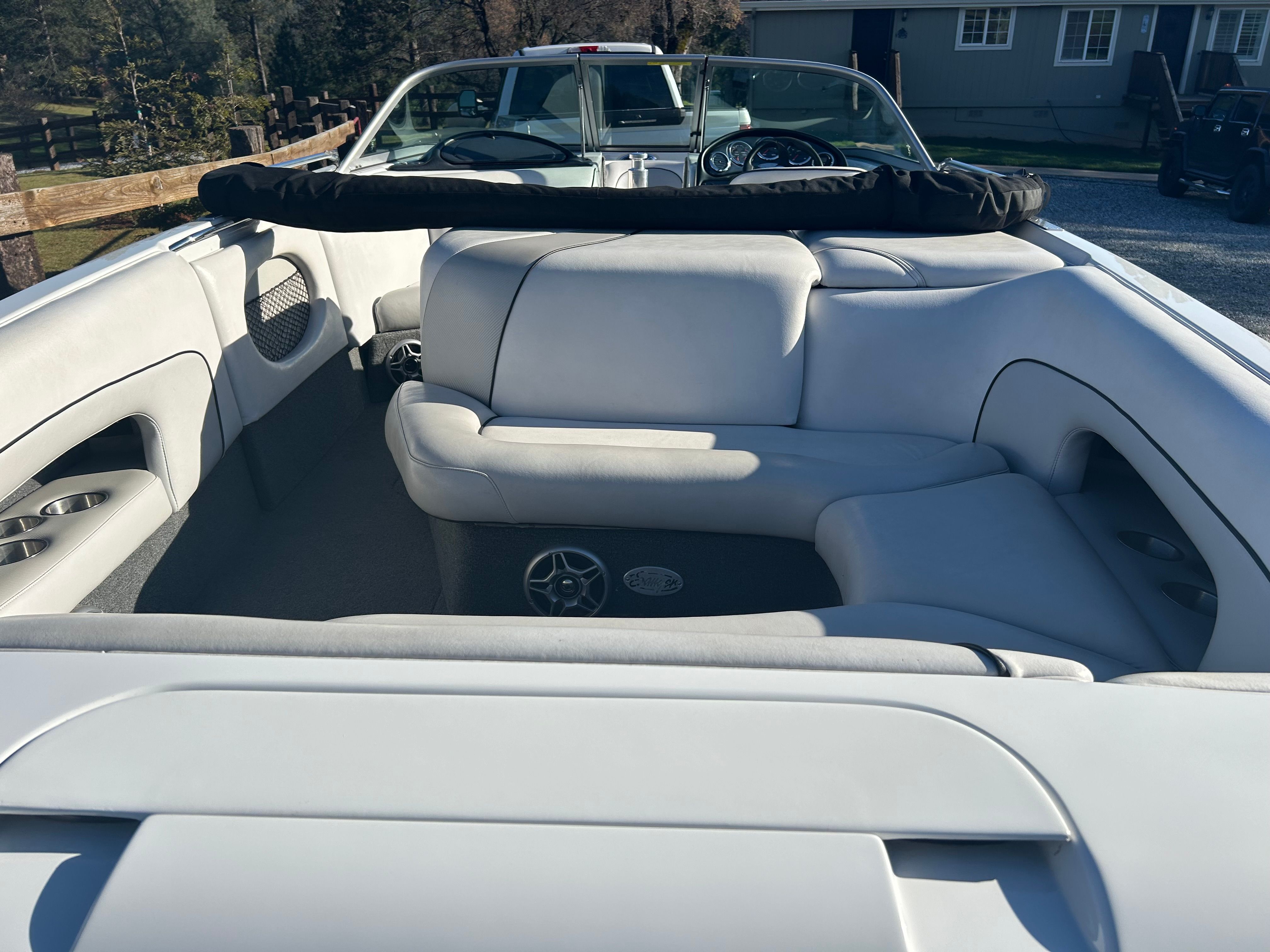 Interior view of a Sanger boat with white seating and steering wheel.