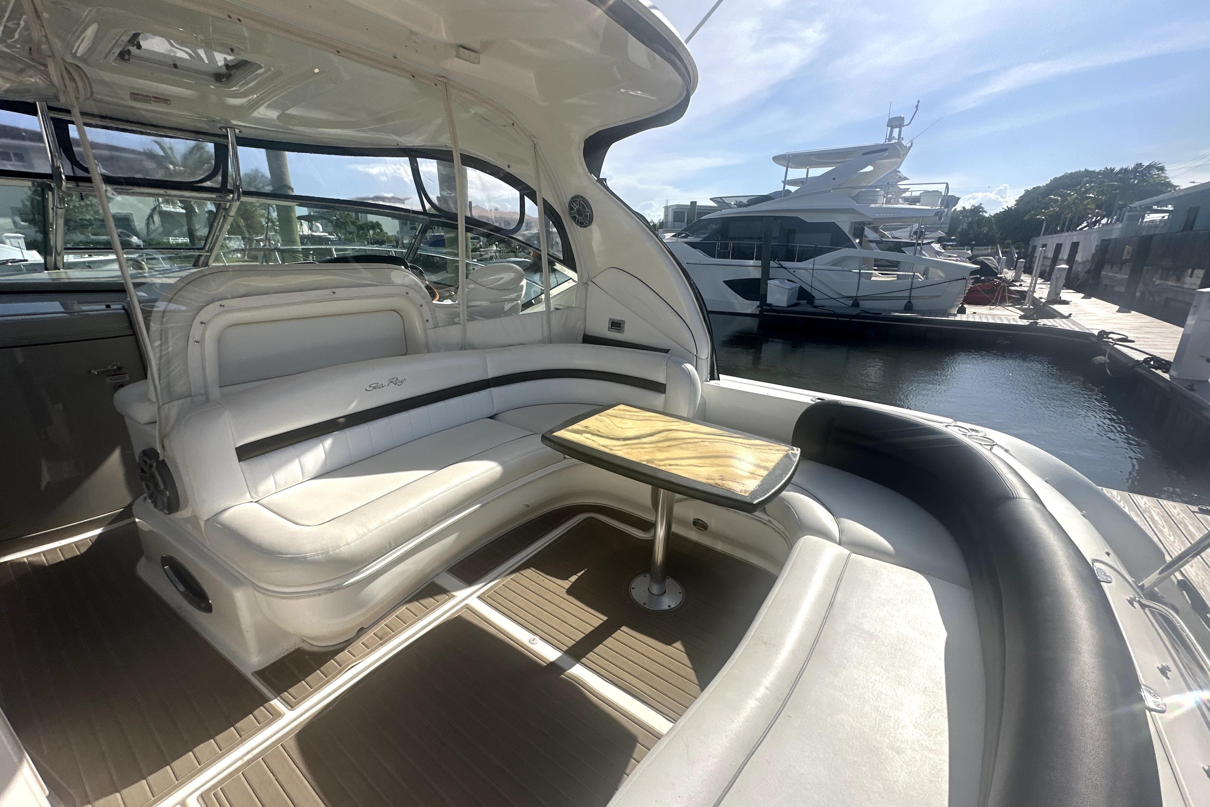 Luxurious 2007 Sea Ray 44 Sundancer yacht interior with elegant seating and table, docked at marina.