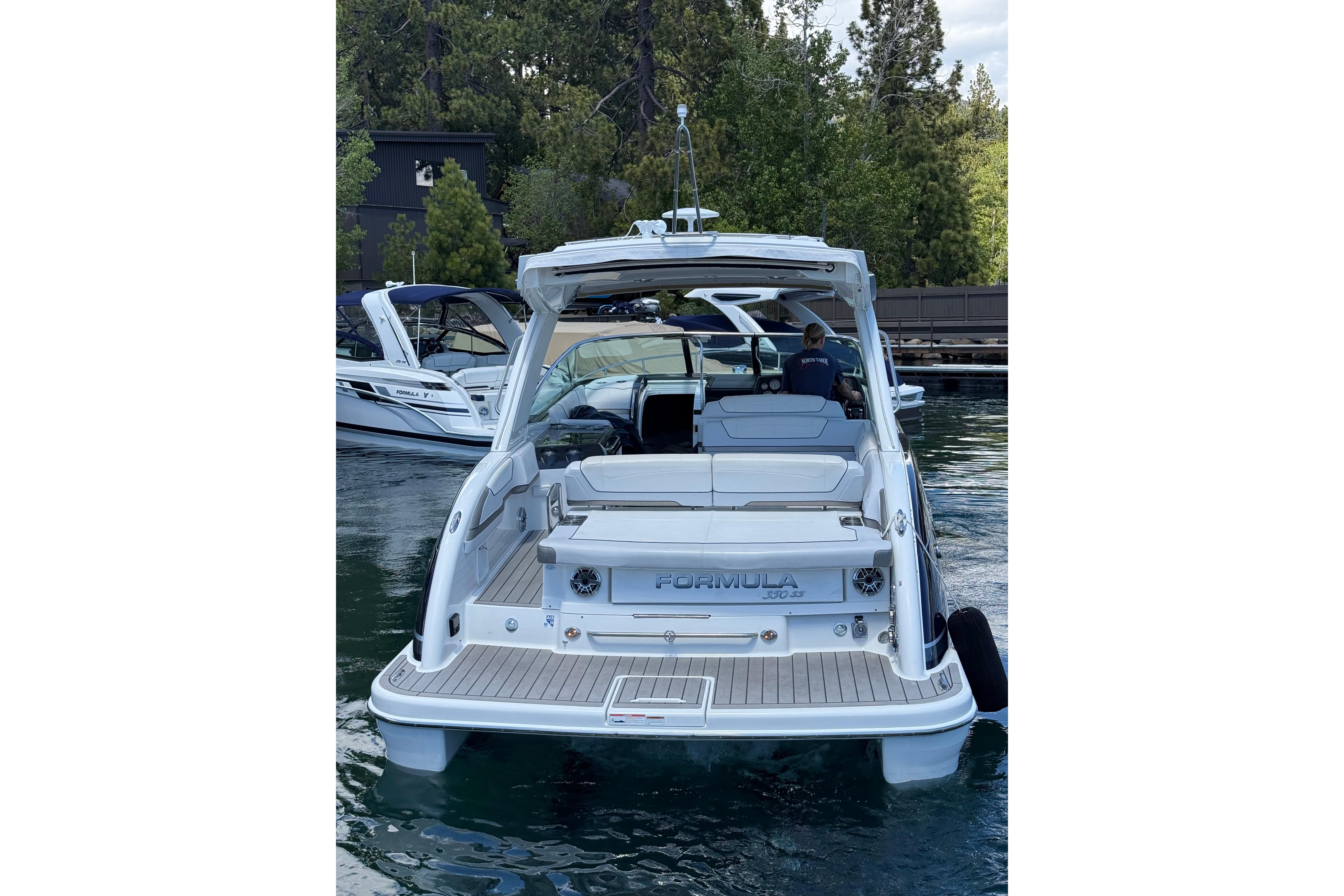 2021 Formula 350 Sun Sport boat docked on a serene lake with lush greenery.