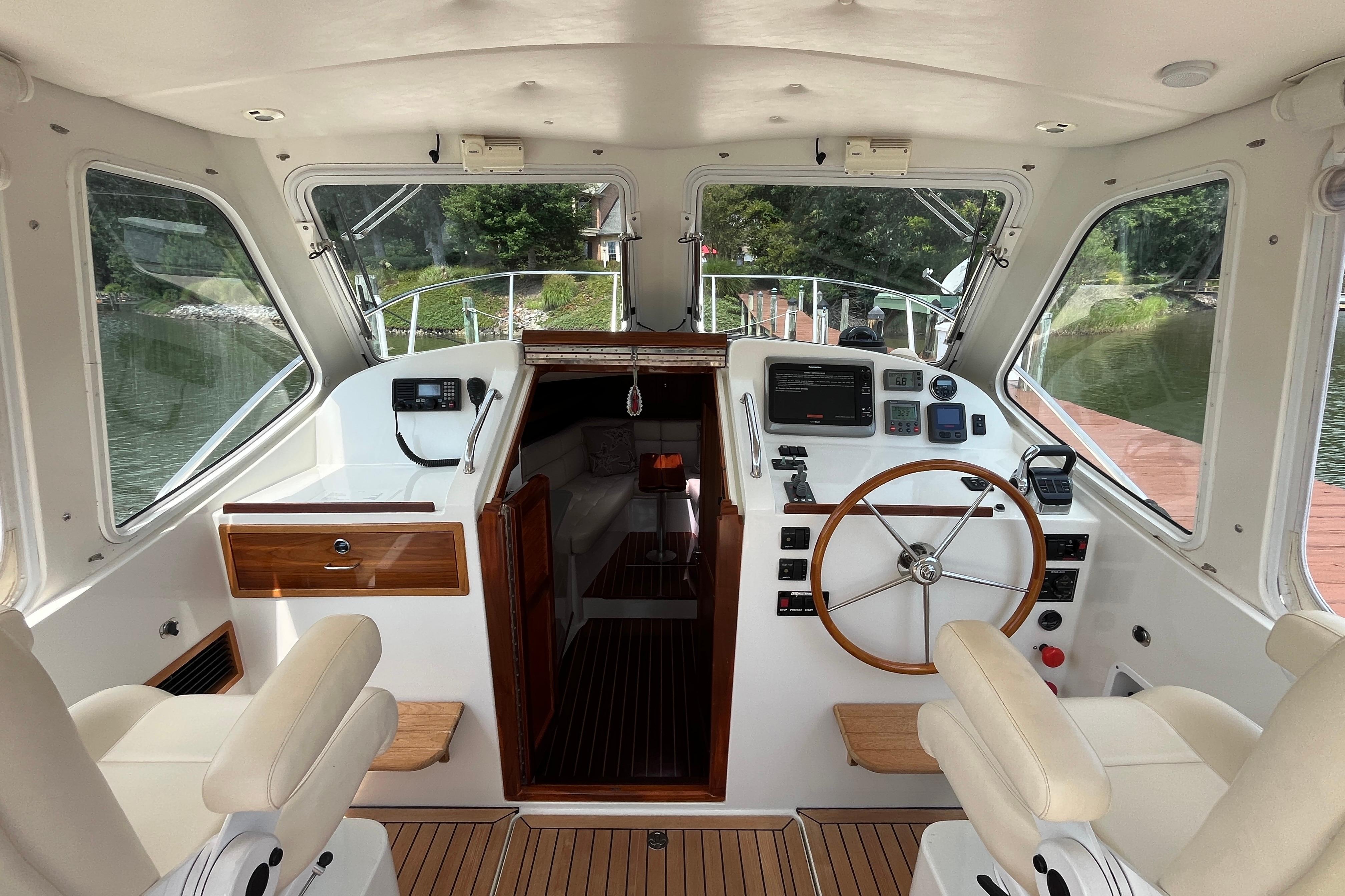 Interior view of 2006 MJM 34z boat cockpit with steering wheel and navigation controls.