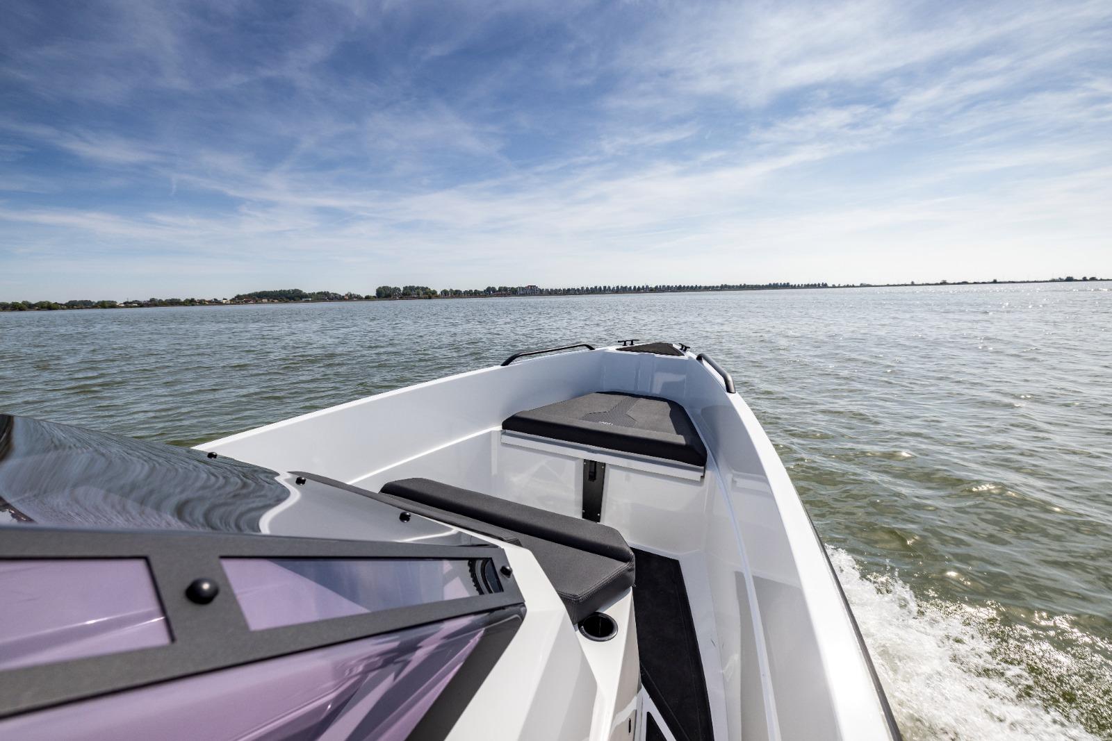 Modern Iron 707 boat cruising on open water under a clear blue sky, 2022 model.