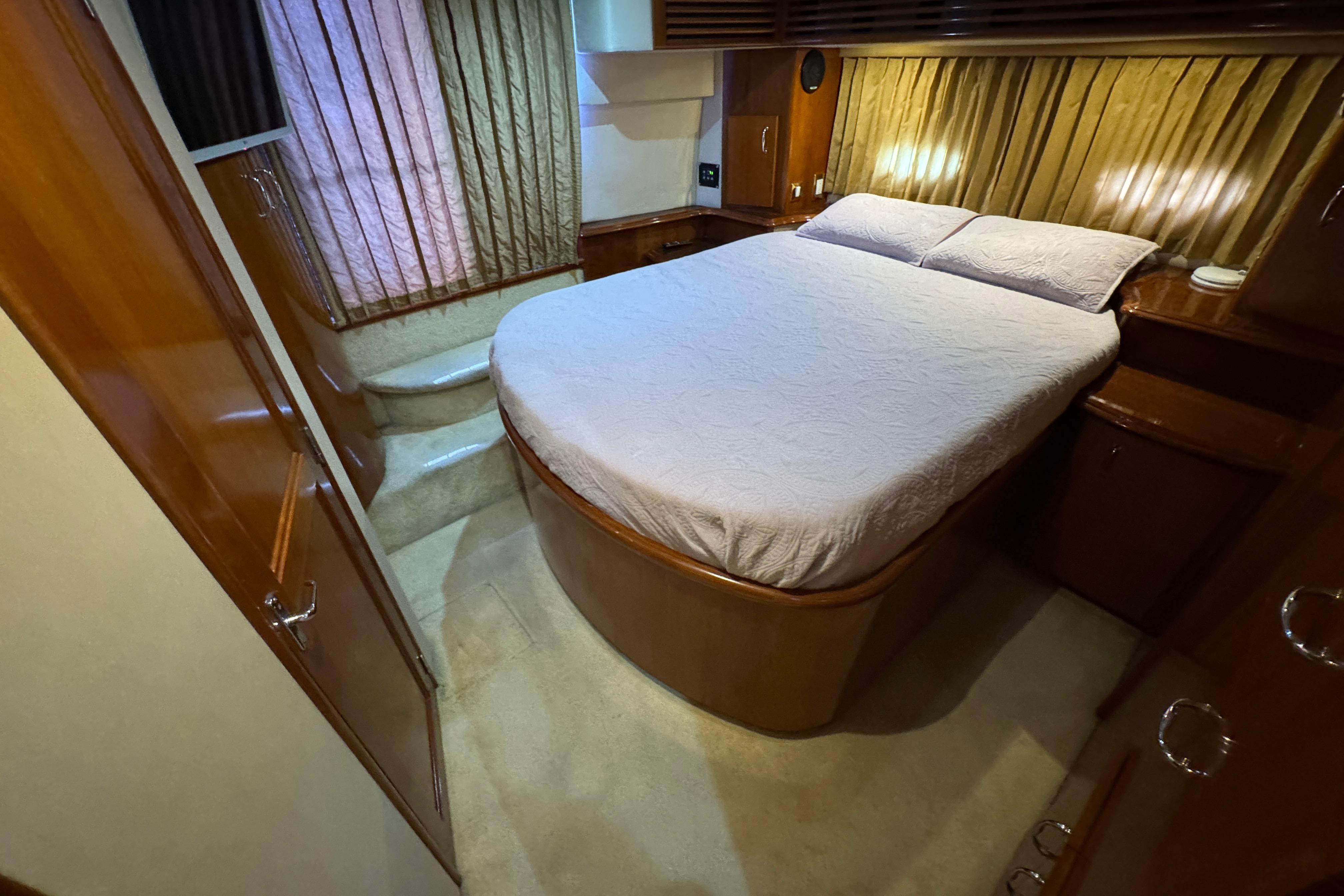 2004 Carver 444 Cockpit Motor Yacht bedroom with cozy bed and elegant wood finish.
