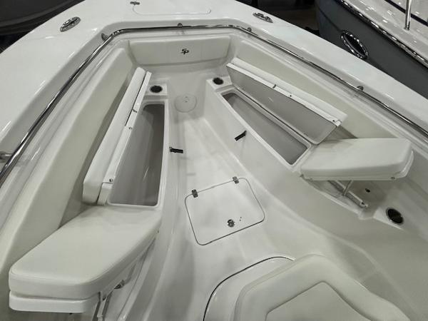 2025 Sea Pro 262 Offshore boat interior with white seating and storage compartments.