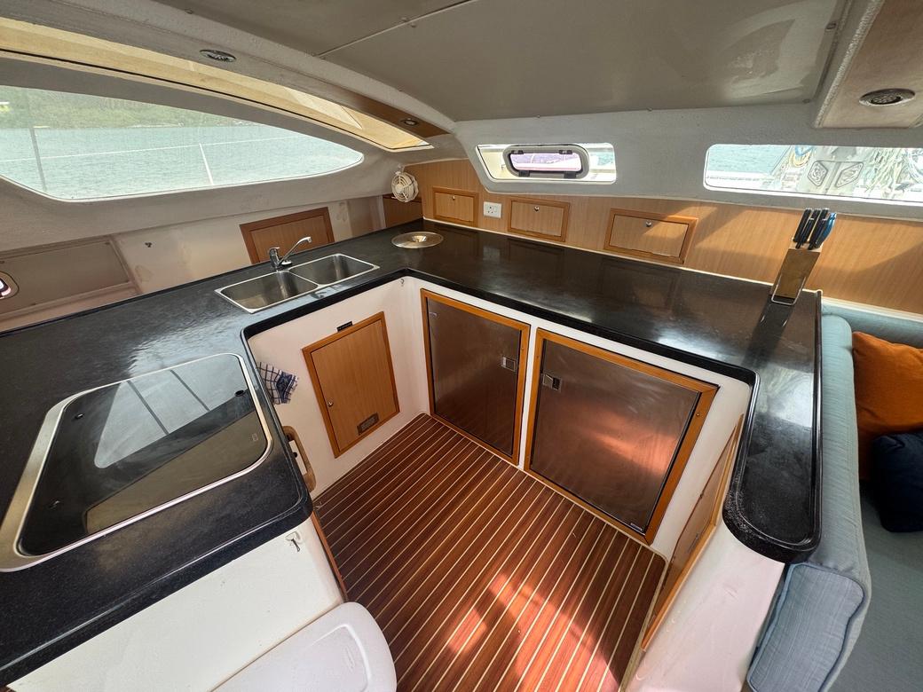 Interior of 2010 Admiral 38 Executive yacht kitchen with sleek countertops and wooden cabinetry.