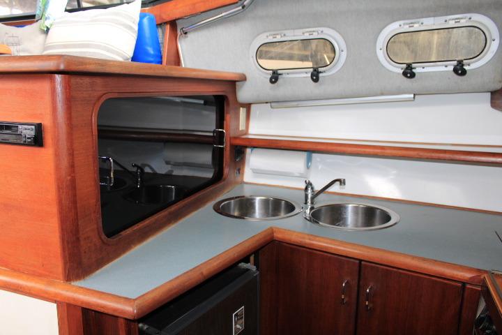 Interior of 1992 Bayliner 3288 Motoryacht kitchen with dual sinks and wooden cabinetry.
