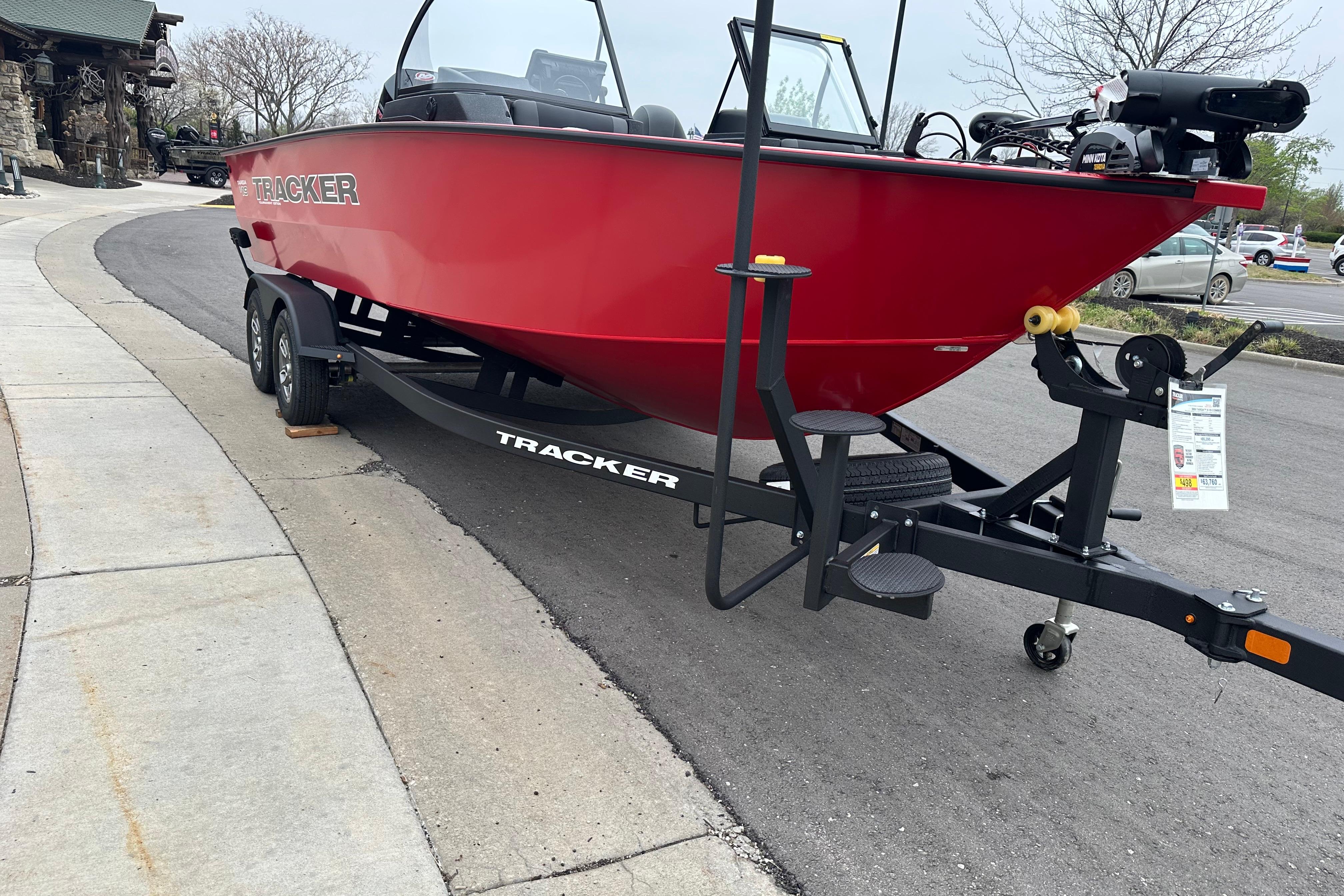 Red 2026 Tracker Targa V-19 Combo boat on trailer, parked on a street.