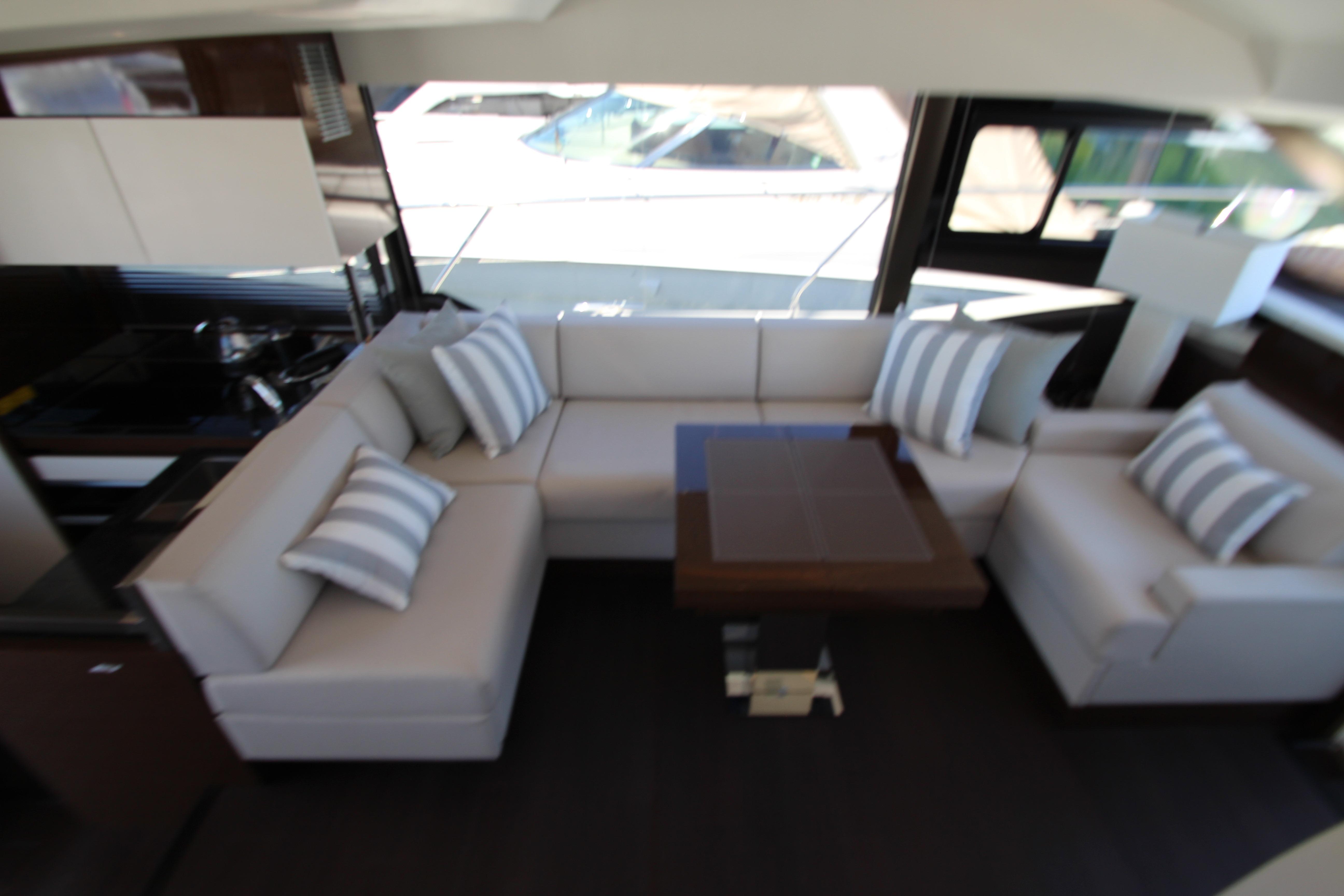Luxurious interior of 2022 Prestige 520 yacht with elegant seating and striped cushions.