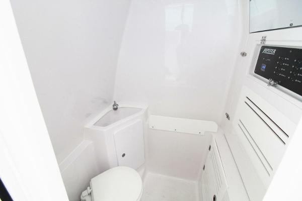 2024 Jupiter 34 HFS boat interior bathroom with white fixtures and compact design.
