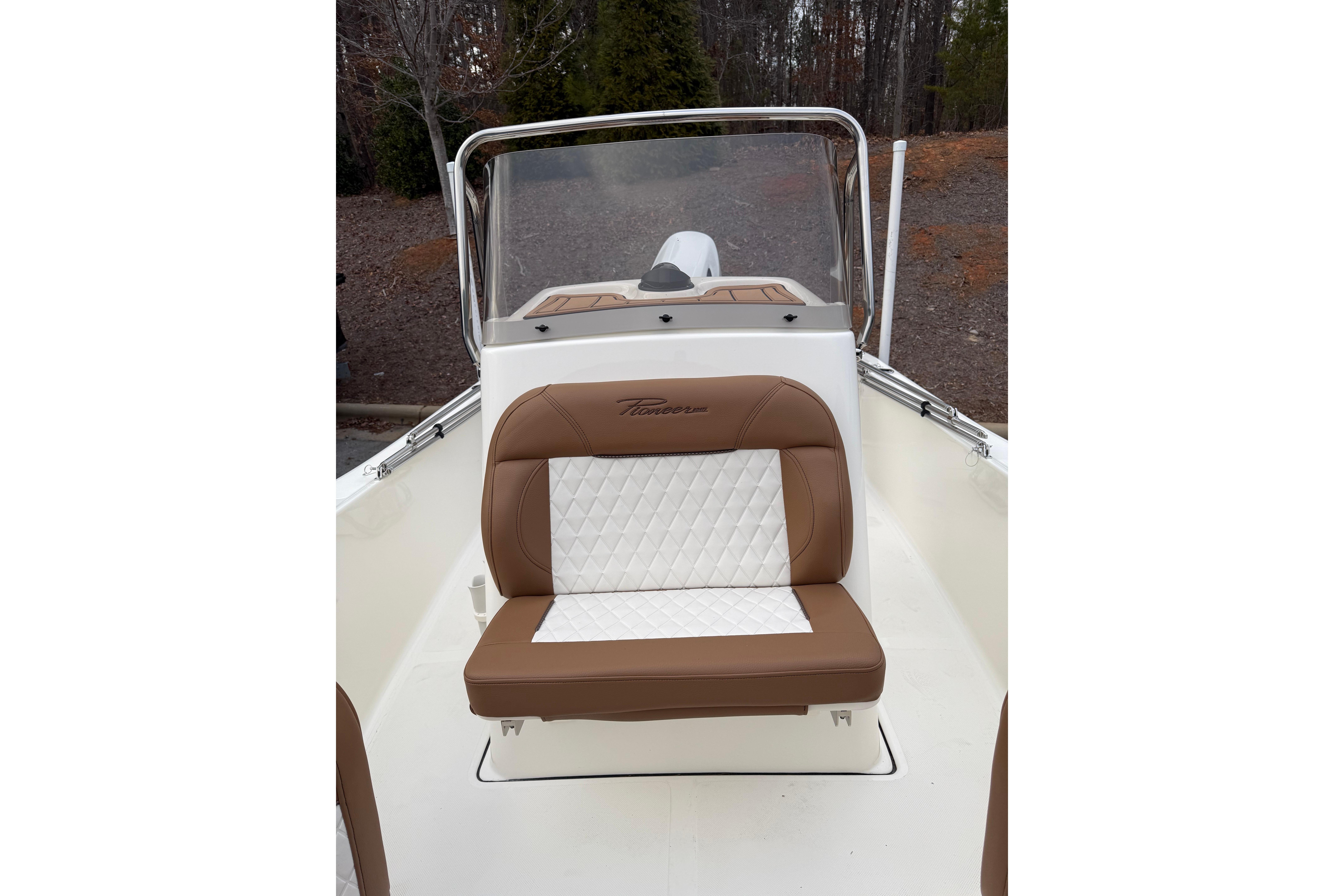2026 Pioneer 180 Islander boat with brown and white seating, outdoors.