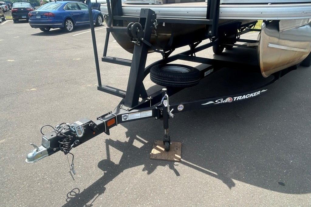 2023 Sun Tracker Party Barge 22 DLX trailer hitch in parking lot.