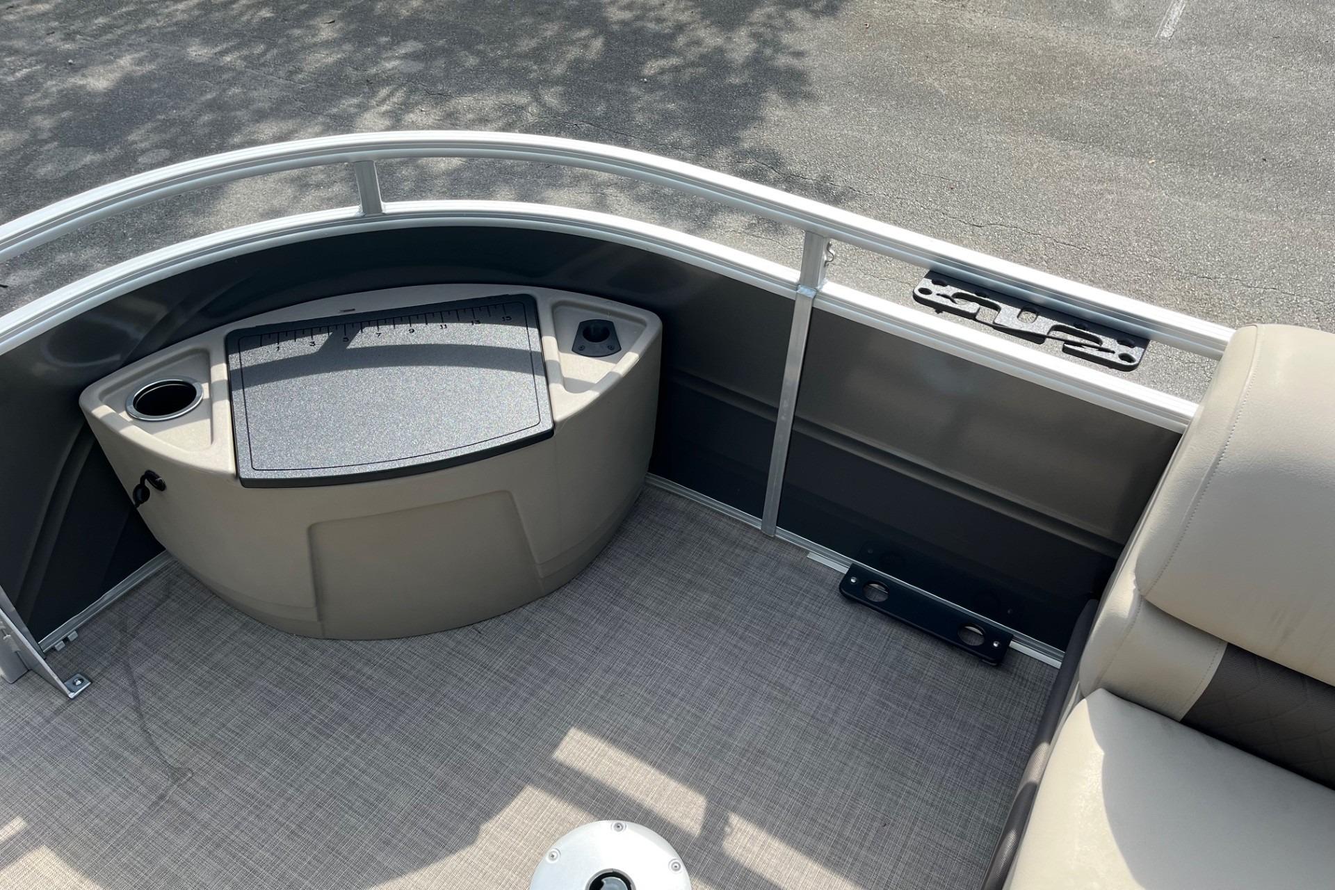 2025 Sun Tracker Fishin' Barge 20 DLX interior with seating and storage area.