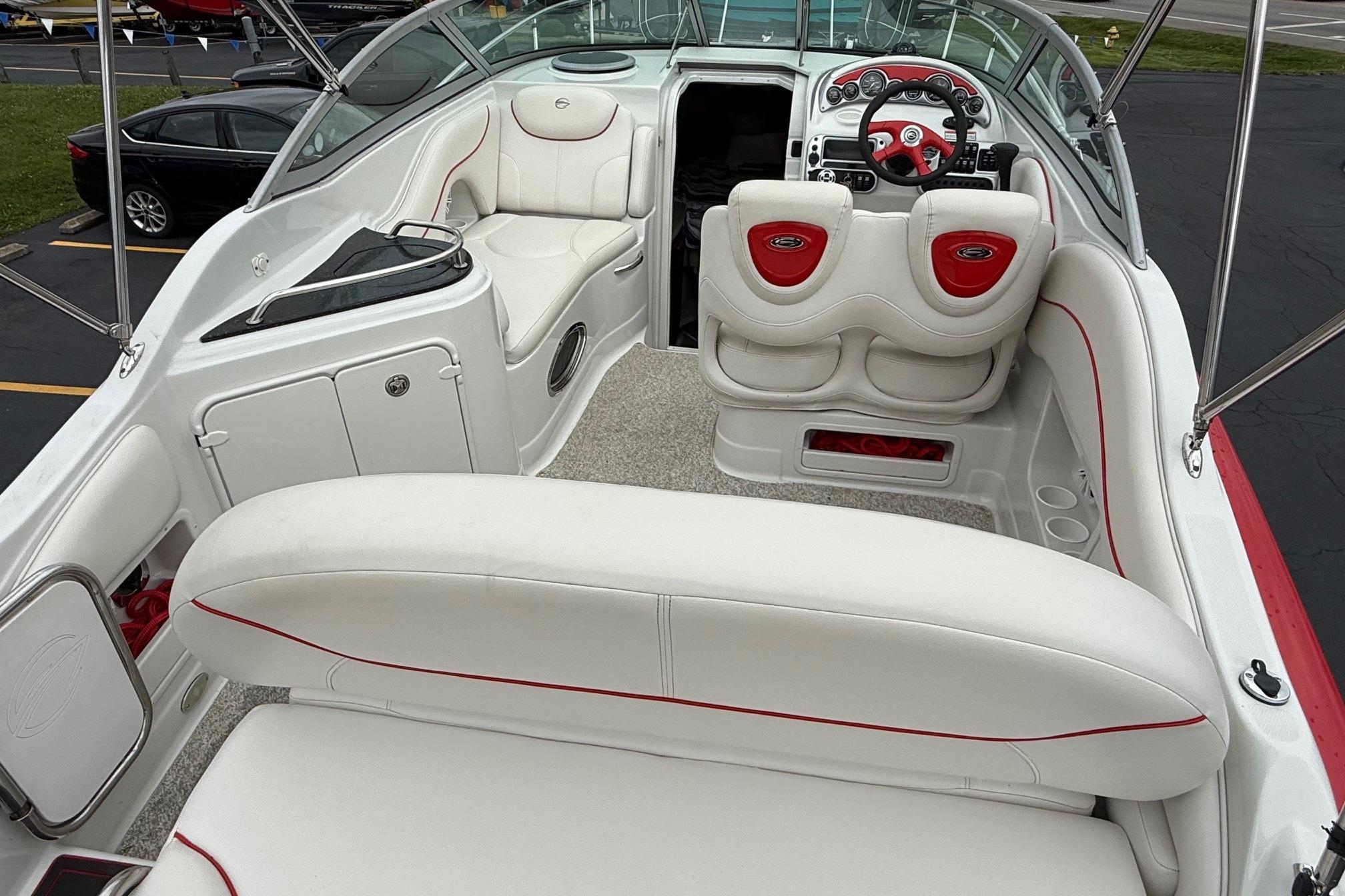 2005 Crownline 250 CR boat interior with white and red seating, steering console, and spacious layout.