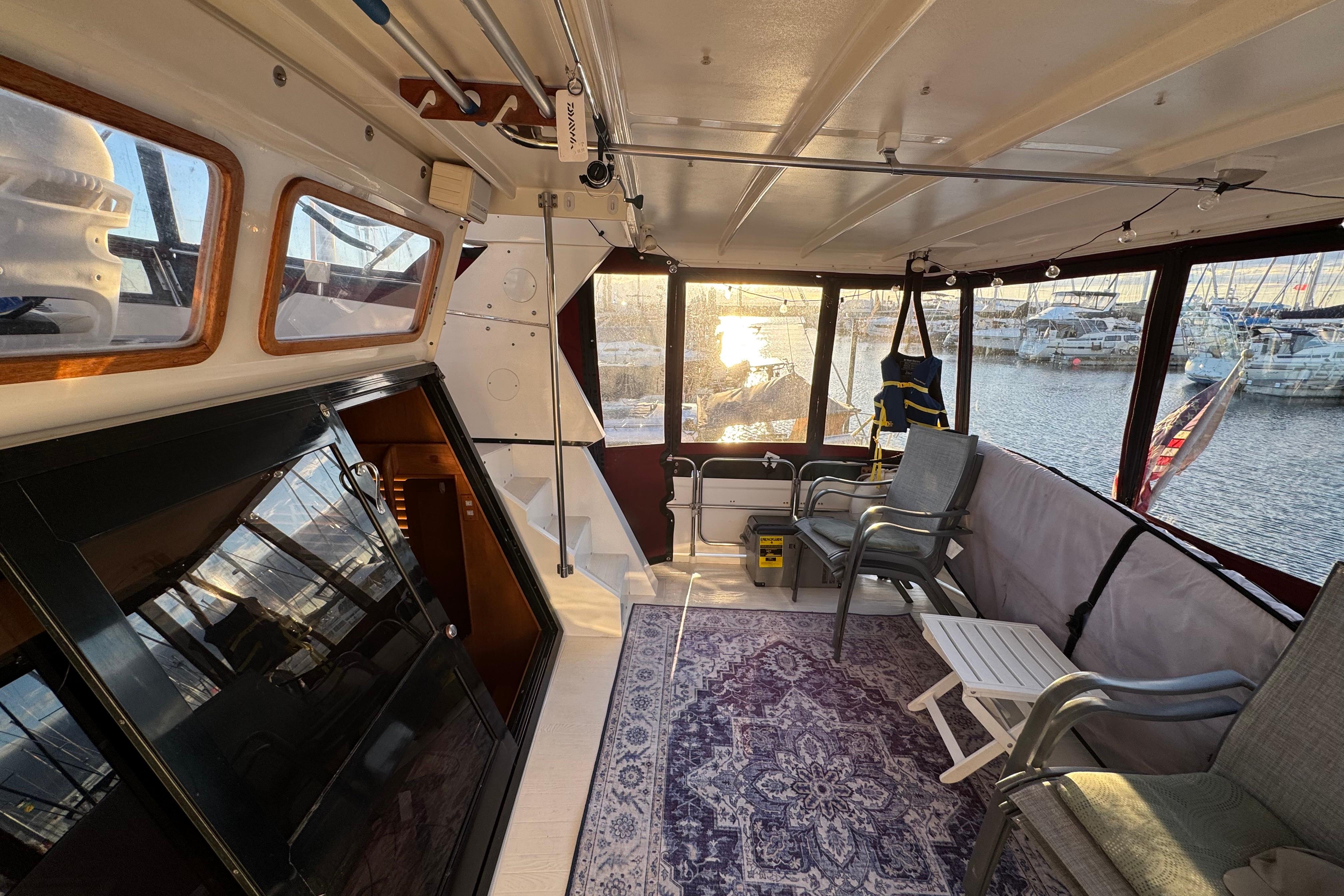 Interior of a 1987 President 37 yacht with seating, table, and marina view.