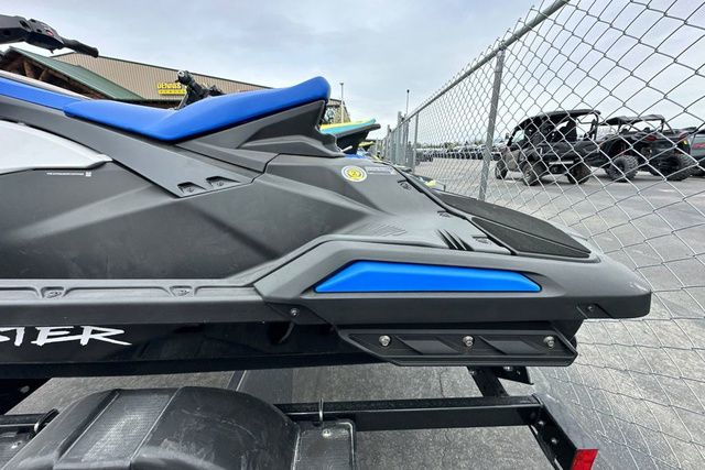 A Yamaha WaveRunner Jetblaster in black sits on a trailer next to a chain-link fence.