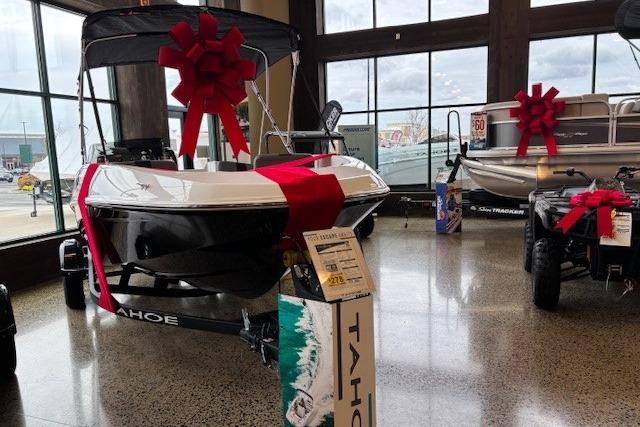 2026 Tahoe T16 boat with red bow on display in showroom.