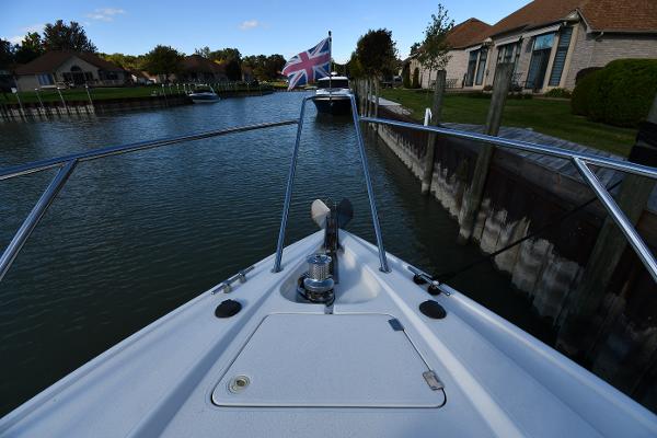 Bow view of 1997 Sunseeker Camargue 47 yacht in a canal with a British flag.